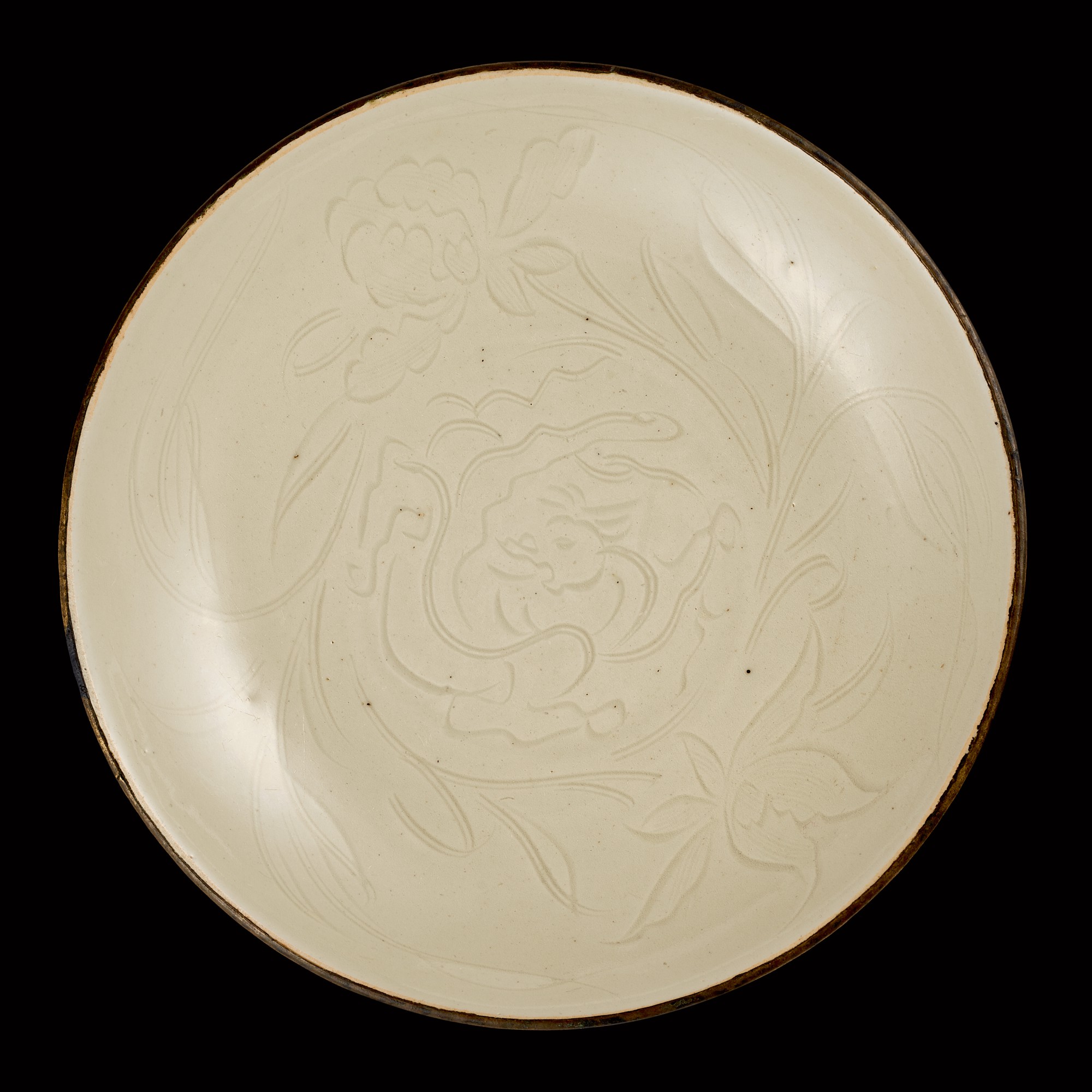 A rare carved Dingyao 'chilong' dish — 宋 定窰白釉刻螭龍牡丹紋盤