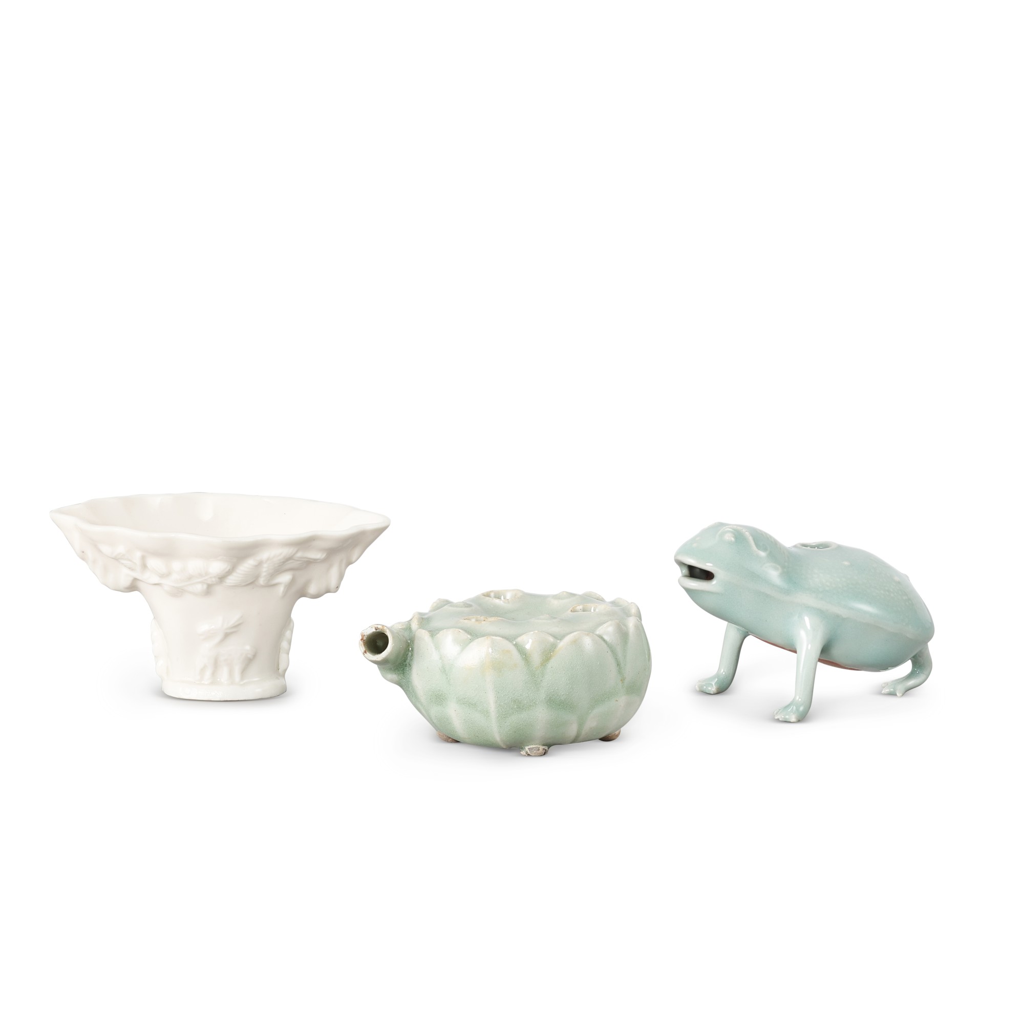 A Dehua libation cup and two Longquan celadon waterpots, — A Dehua libation cup and two Longquan celadon waterpots, Qing dynasty  清 德化白釉鹿鶴同春盃一件 及 龍泉青釉蓮蓬形及金蟾形水盂兩件