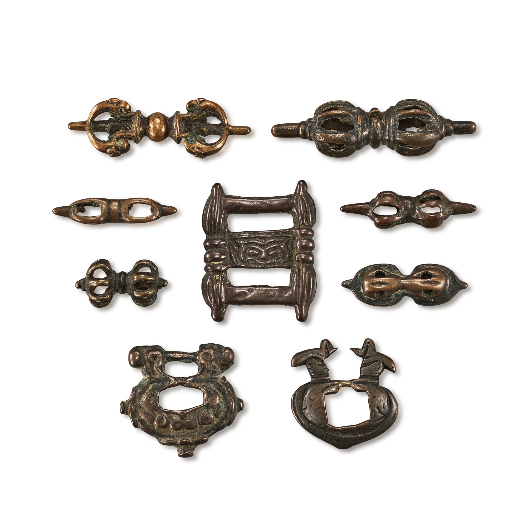A group of 9 copper-alloy 'vajra' thogchags and buckles, — A group of 9 copper-alloy 'vajra' thogchags and buckles, Tibet, 12th - 15th century 十二至十五世紀 西藏 各式金剛杵天鐵及經書扣一組九件