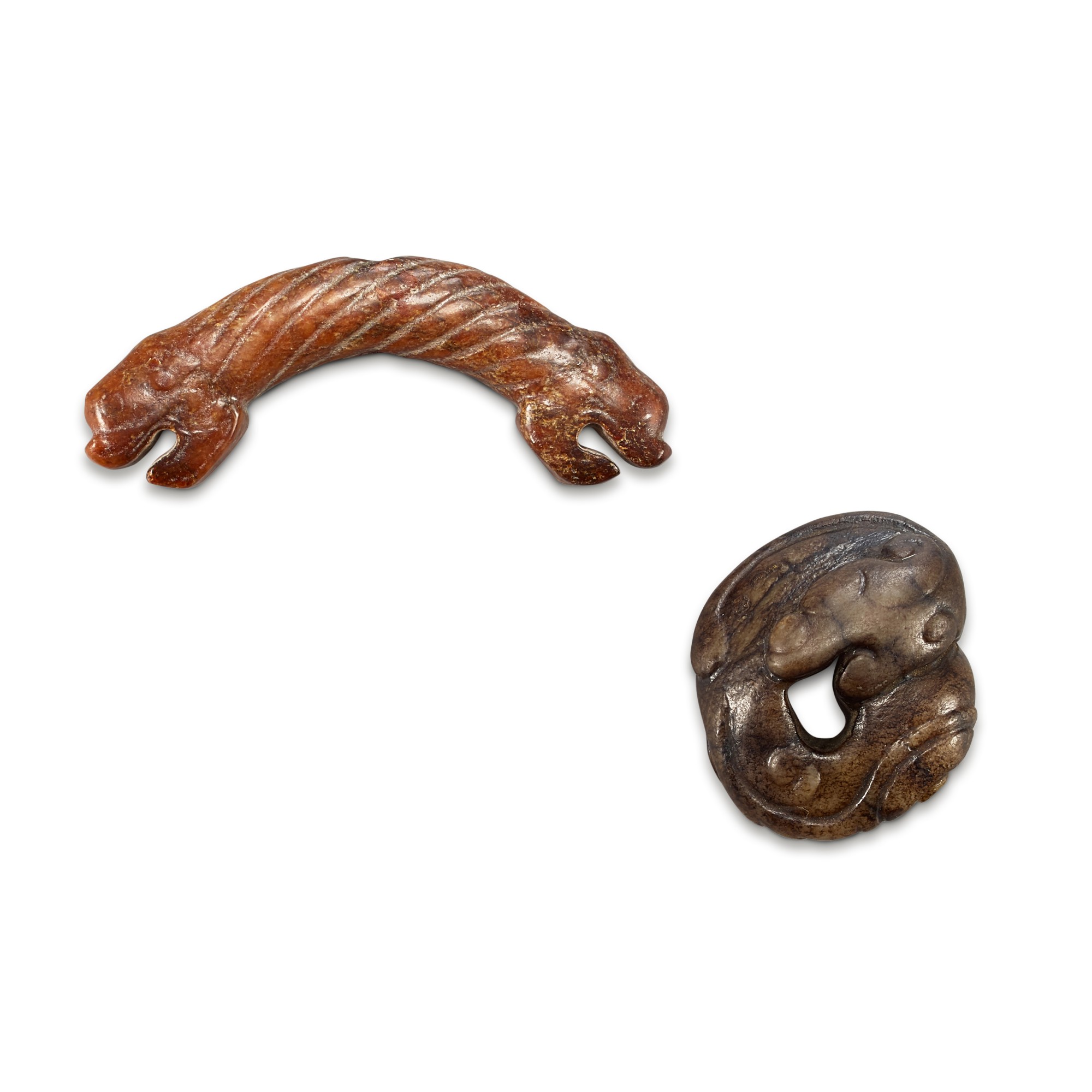 A brown jade 'dragon' Huang and a brown and black jade ‘dragon’ pendant, — A brown jade 'dragon' Huang and a brown and black jade ‘dragon’ pendant, Song dynasty 宋 玉龍首璜及珮飾一組兩件