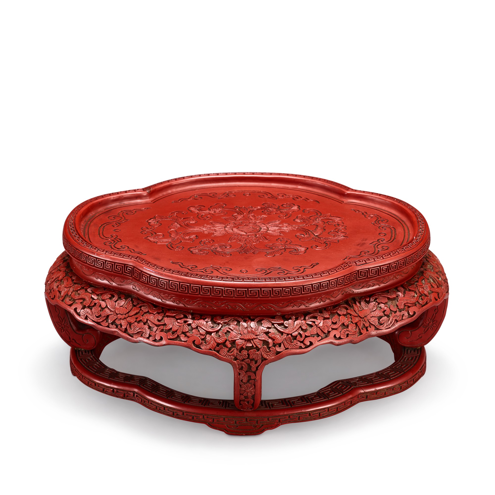 A cinnabar lacquer quatrelobed 'lotus' stand, — A cinnabar lacquer quatrelobed 'lotus' stand, Qing dynasty, Qianlong period 清乾隆 剔紅蓮紋海棠式座