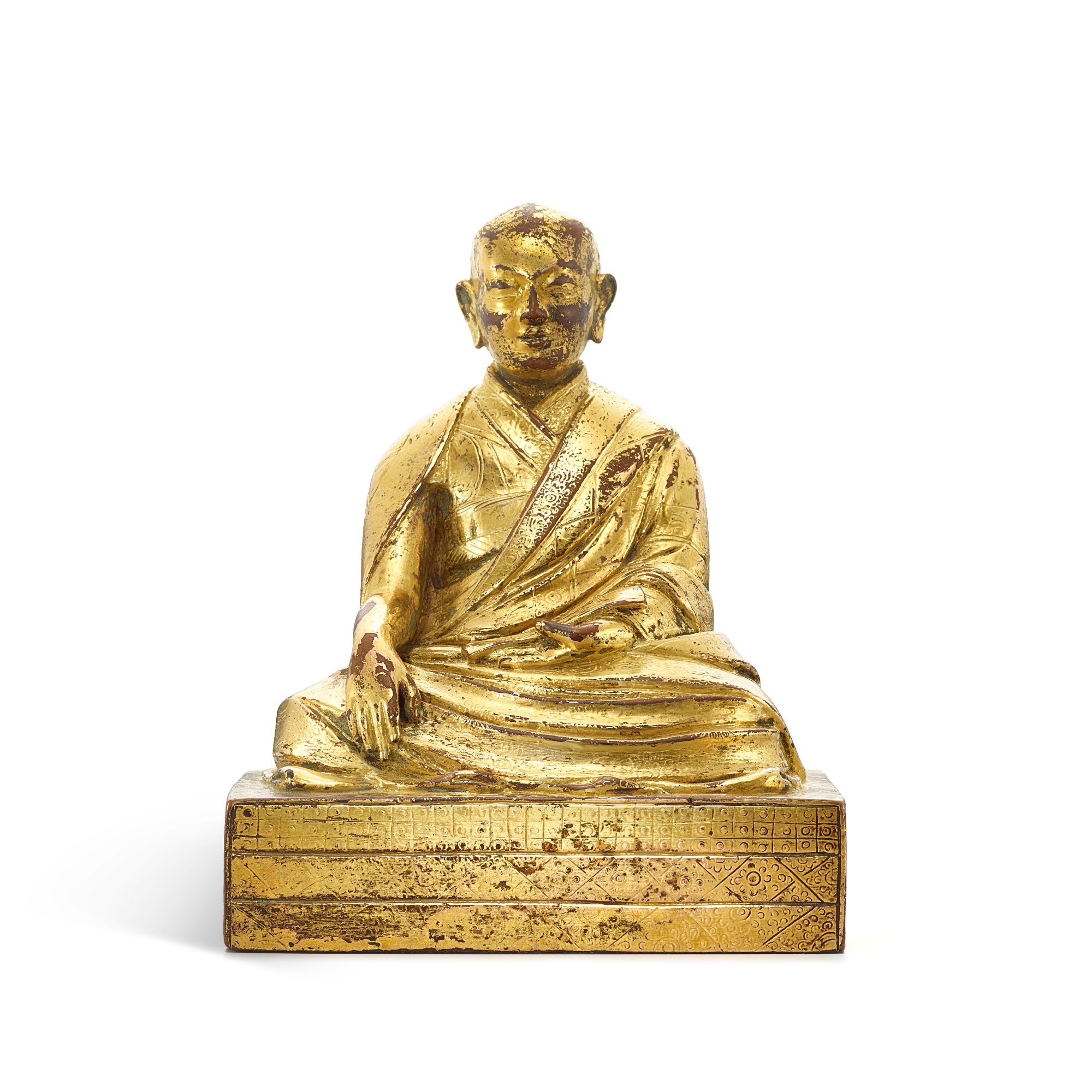 A gilt-bronze figure of a lama, — A gilt-bronze figure of a lama, Tibet, 18th century 十八世紀 藏傳鎏金銅喇嘛坐像