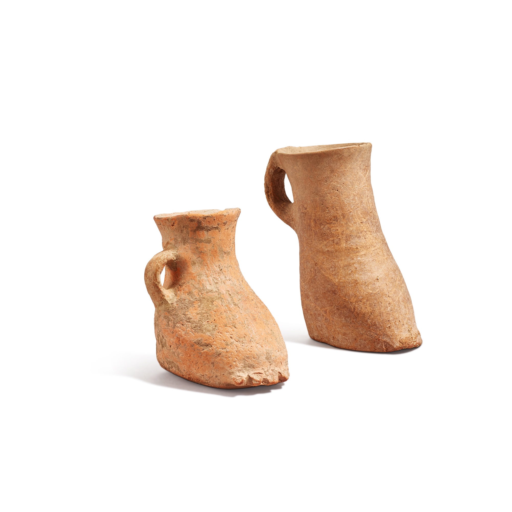 Two red pottery boot-form cups,
