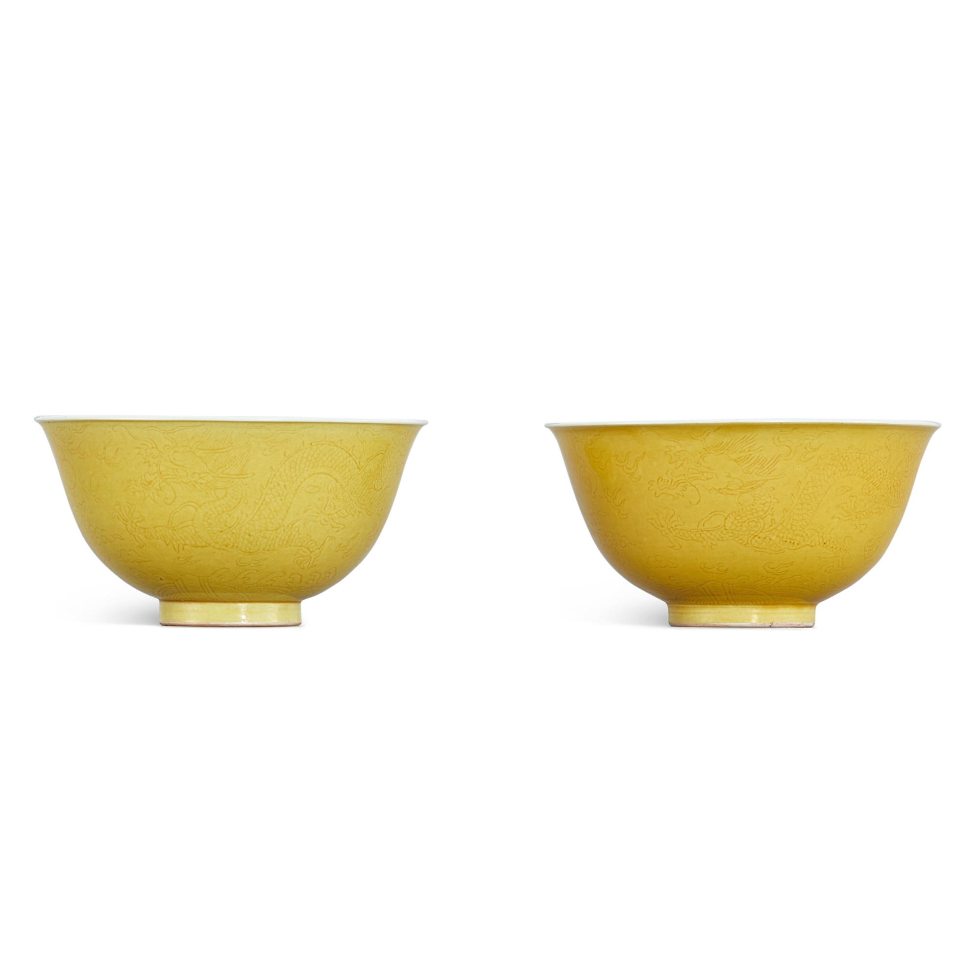 Unknown (Historical) — A pair of incised yellow-glazed 'dragon' bowls, Seal marks and period of Jiaqing 清嘉慶 黃釉暗刻雲龍趕珠紋盌一對 《大清嘉慶年製》款