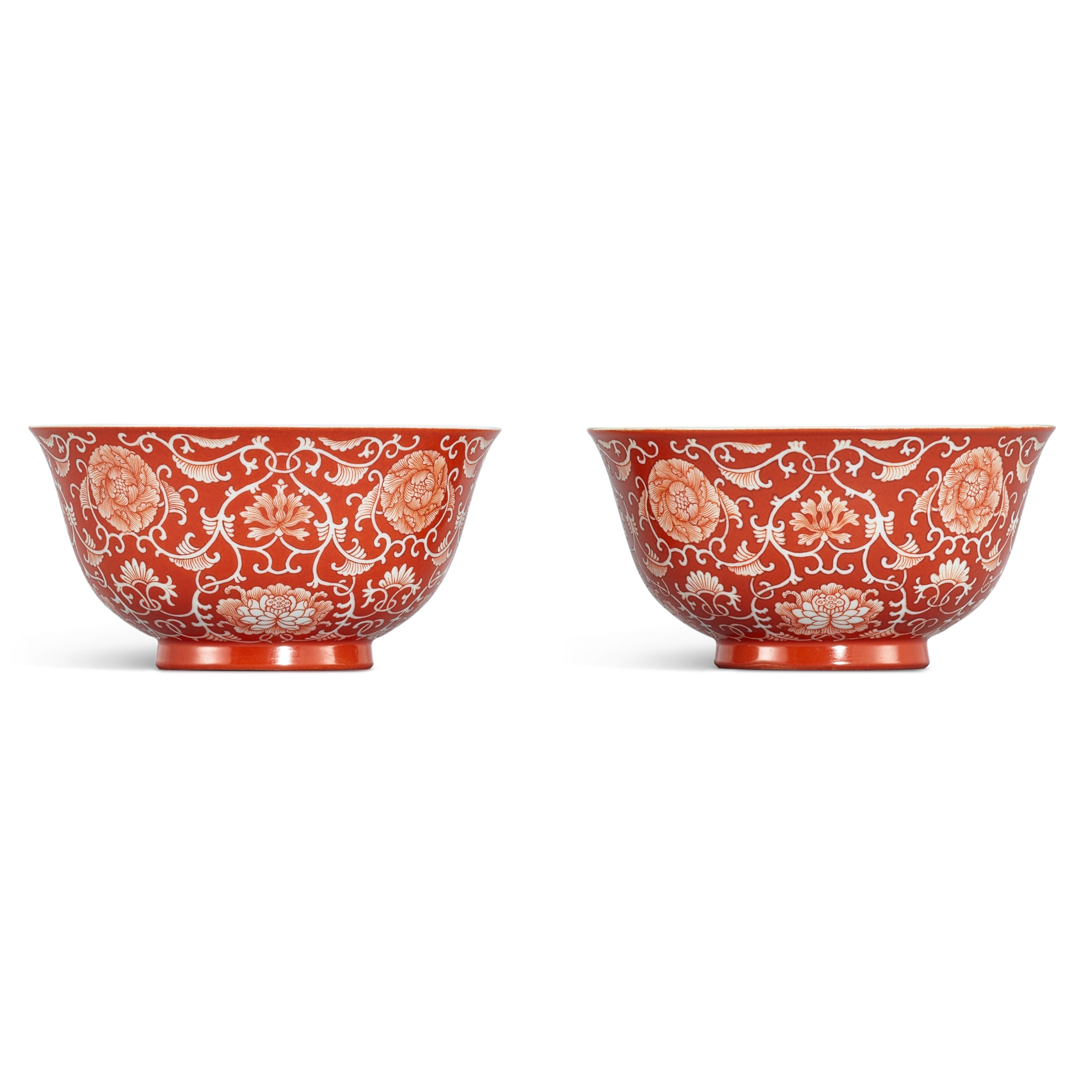 Unknown — A fine pair of coral-red reverse-decorated 'lotus' bowls, Seal marks and period of Qianlong 清乾隆 珊瑚紅地留白纏枝蓮花紋盌一對 《大清乾隆年製》款