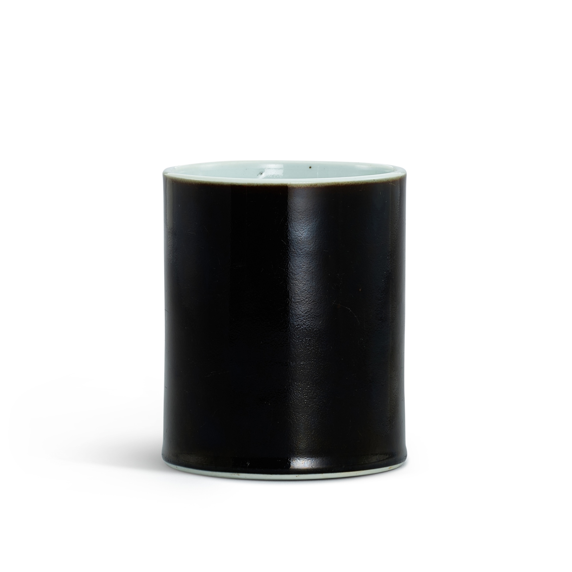 A black-glazed brushpot, — A black-glazed brushpot, Qing dynasty, Kangxi period 清康熙 烏金釉筆筒