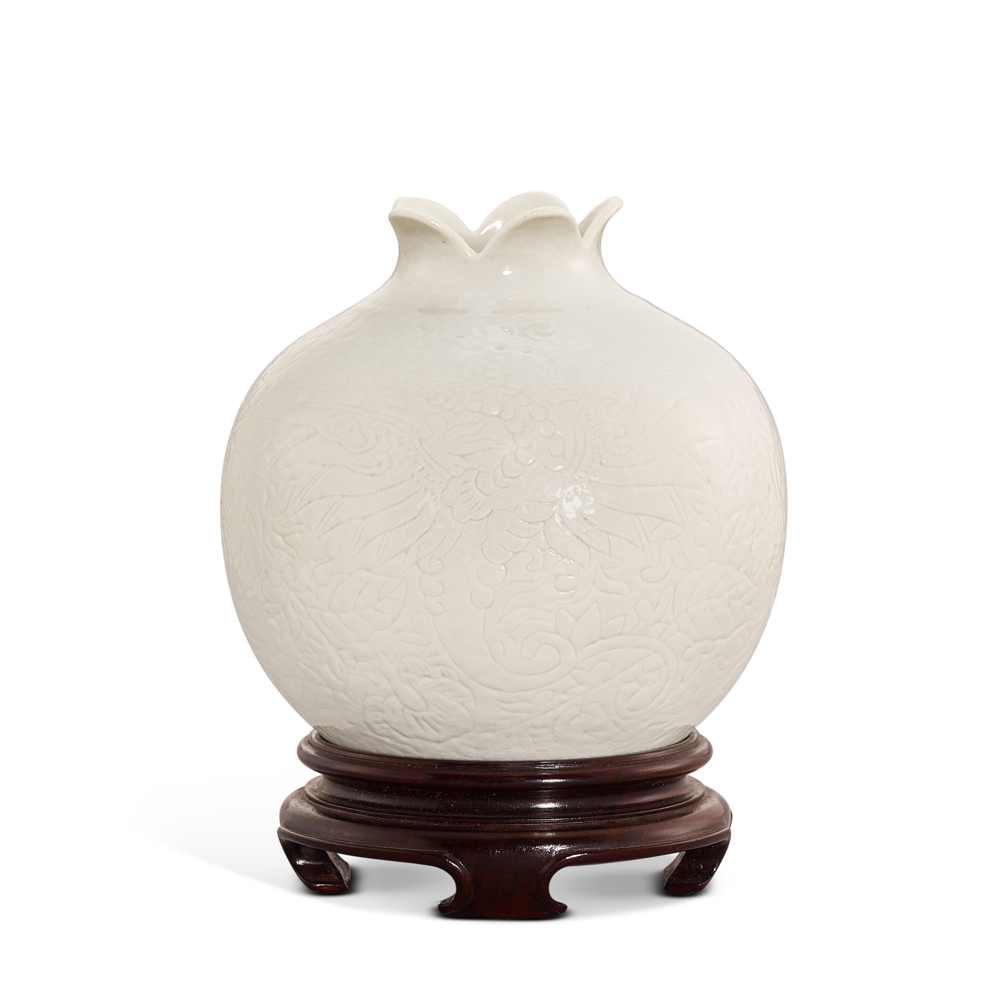 A soft-paste white porcelain carved 'pomegranate' waterpot, — A soft-paste white porcelain carved 'pomegranate' waterpot, Qing dynasty, Qianlong period 清乾隆 漿胎白瓷刻鳳紋石榴尊