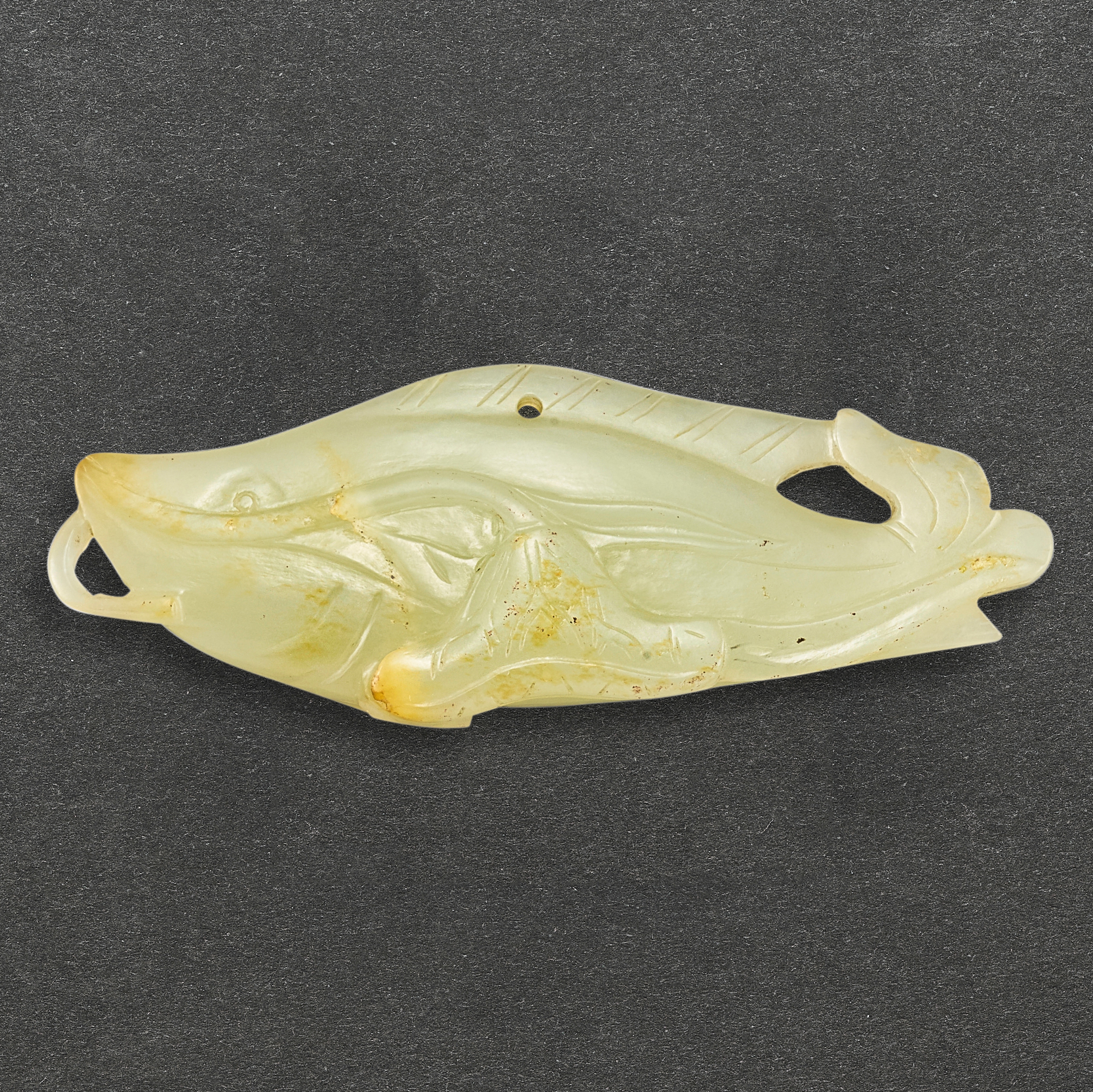 A celadon jade 'fish and lotus' pendant, — A celadon jade 'fish and lotus' pendant, Qing dynasty 清　青白玉鯰魚荷花珮飾