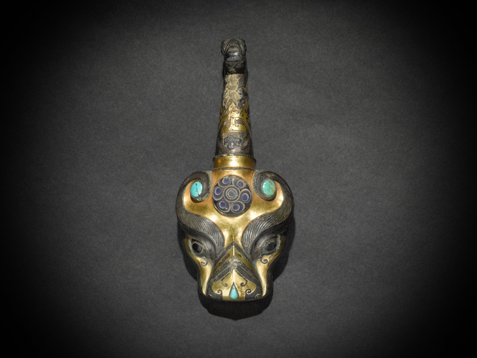 An embellished gold- and silver-inlaid bronze 'tiger' garment hook, — 東周 銅嵌寶錯金銀獸首帶鉤