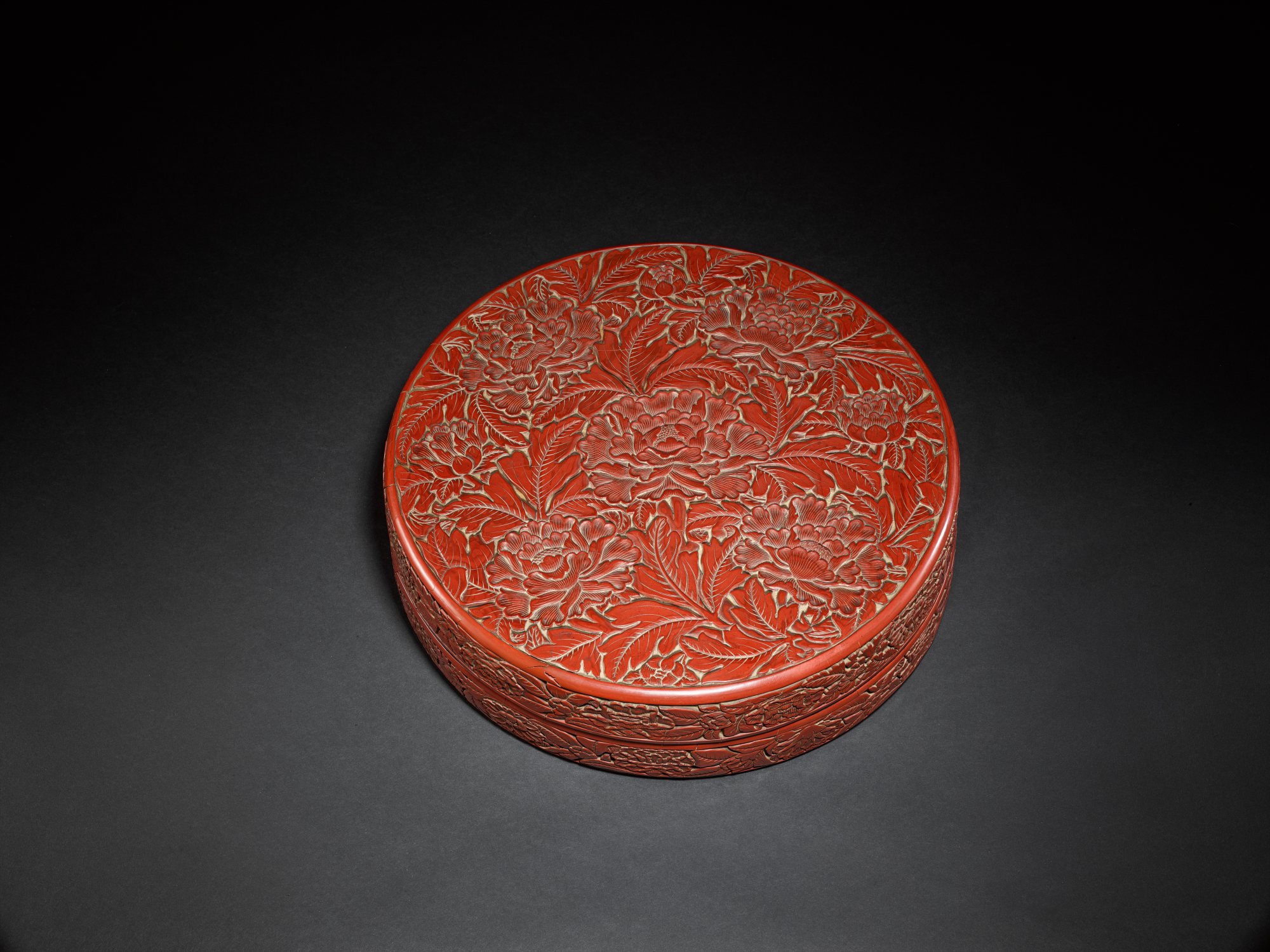 A superbly carved large cinnabar lacquer 'peony' box and cover, — 明永樂 剔紅纏枝牡丹紋大圓蓋盒 《大明永樂年製》款