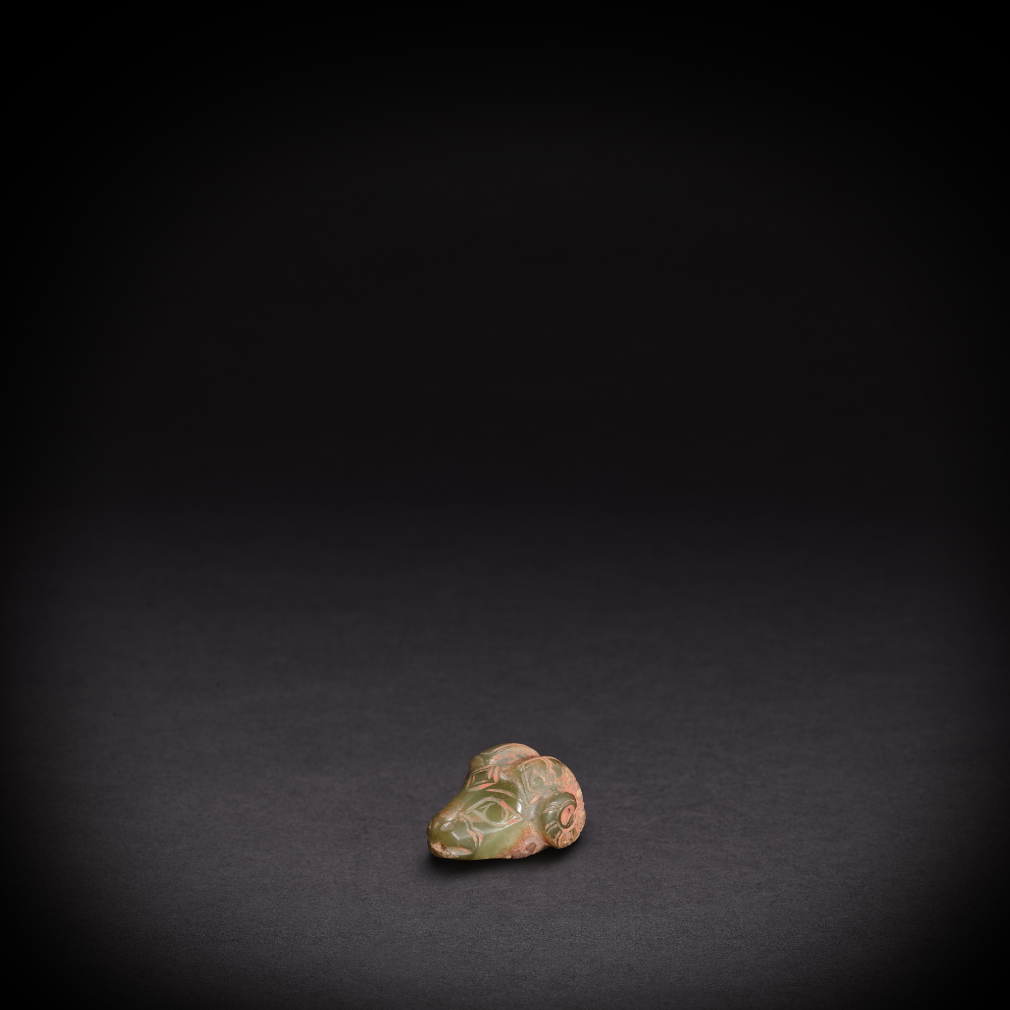 A celadon jade 'ram' pendant — 商 青玉羊首墜