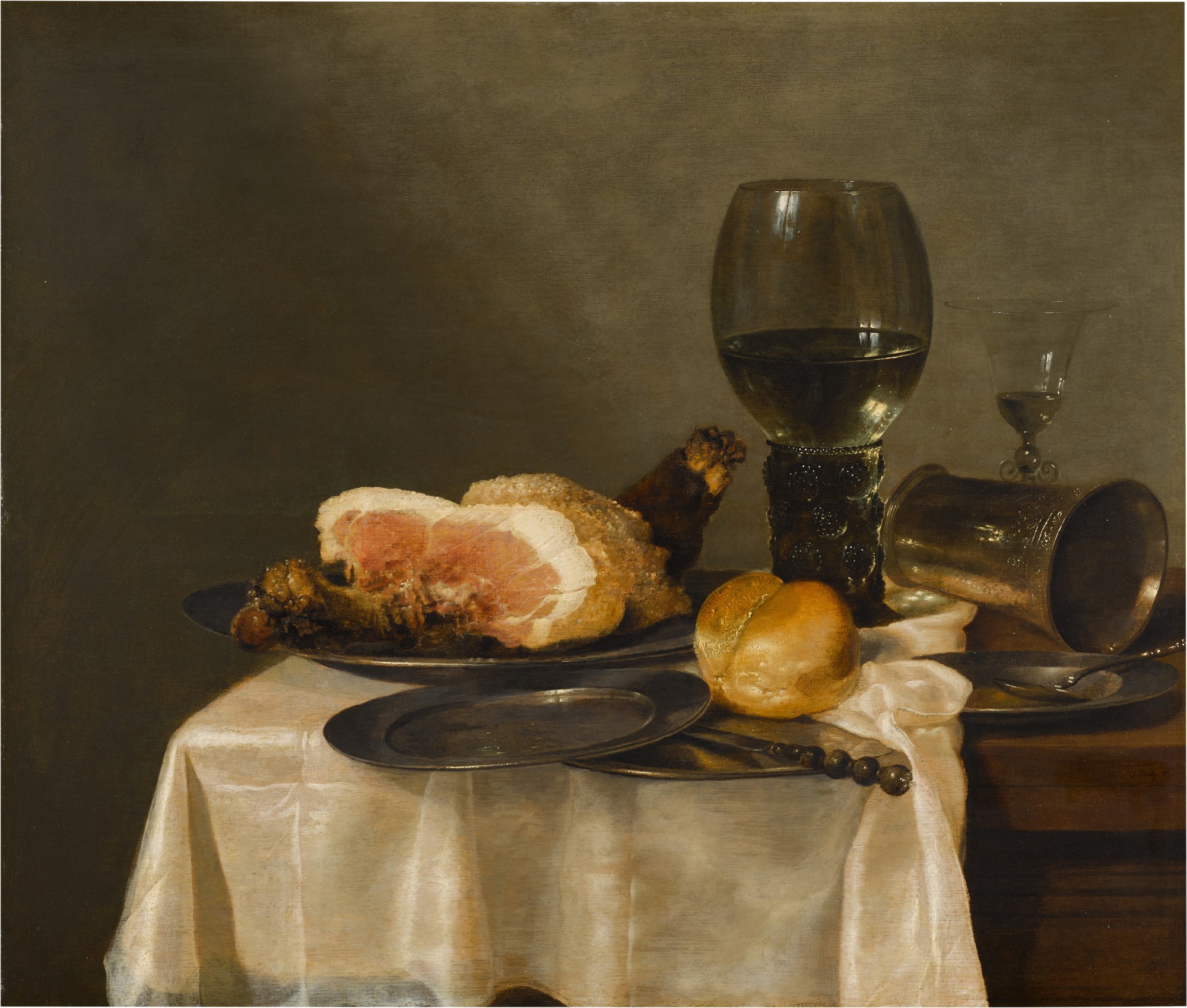 Unknown — Still life with a glass roemer, façon-de-venise wineglass, silver cup, half-cut ham and bread roll with pewter plates, all on a draped table