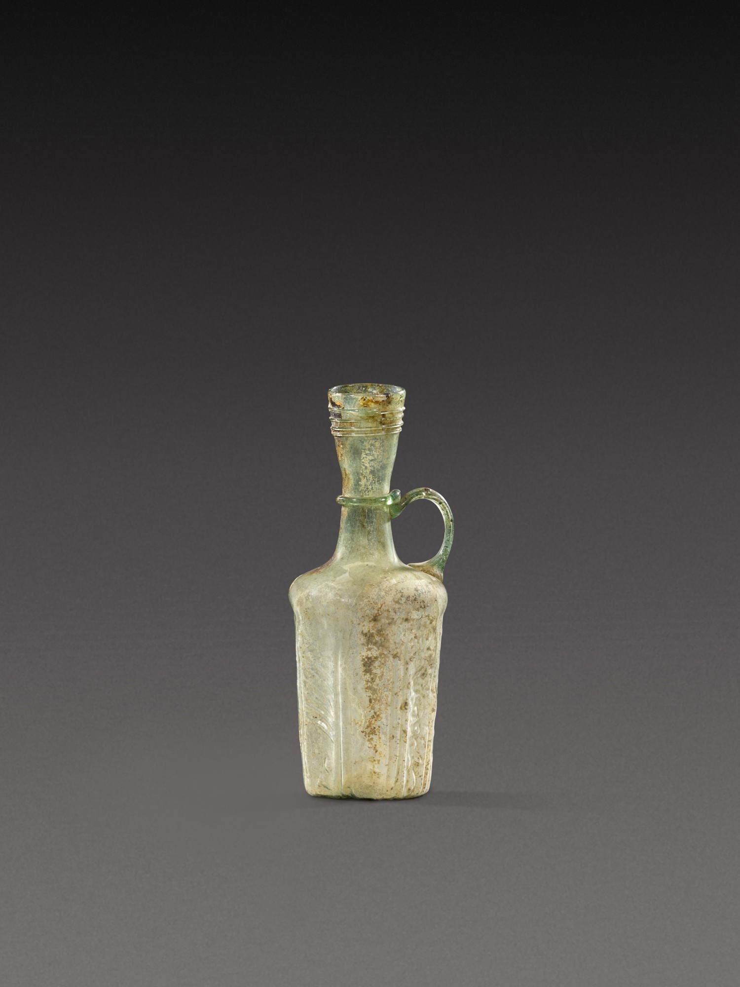 A Roman Pale Green Mould-Blown Glass Jug — A Roman Pale Green Mould-Blown Glass Jug, circa 1st Century A.D.