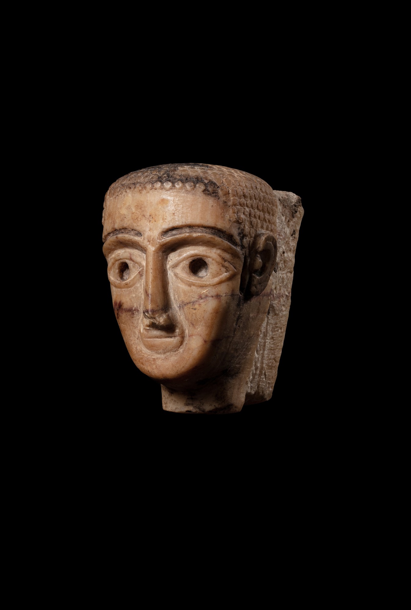 A South Arabian Veined Alabaster Head of a Man or Woman — A South Arabian Veined Alabaster Head of a Man or Woman, 3rd Century B.C./1st Century A.D.