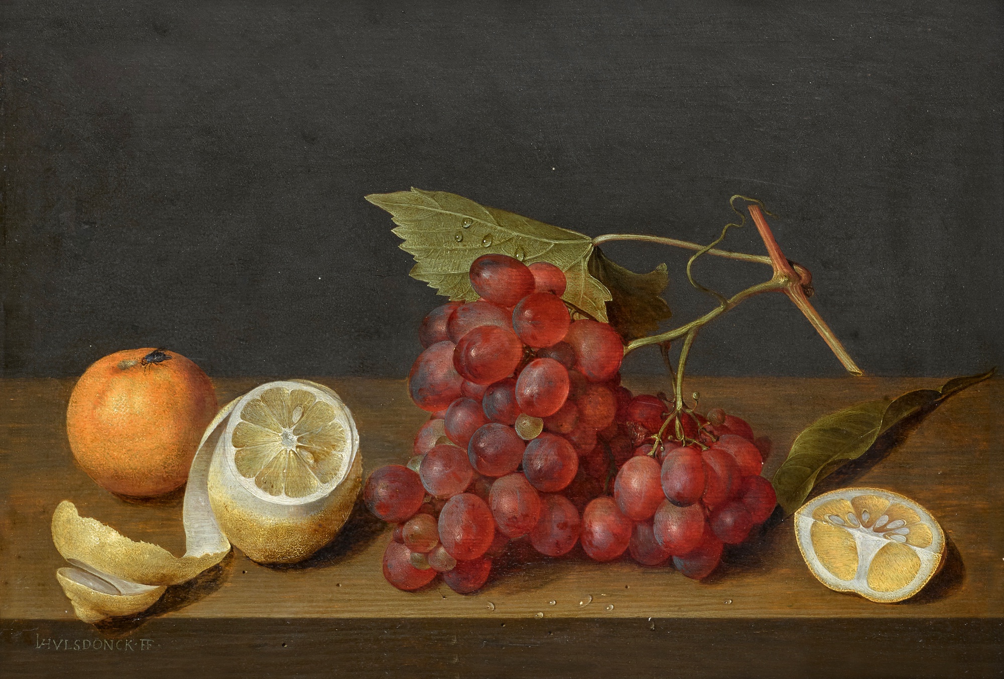 Still life with a bunch of grapes and a peeled lemon on a ledge