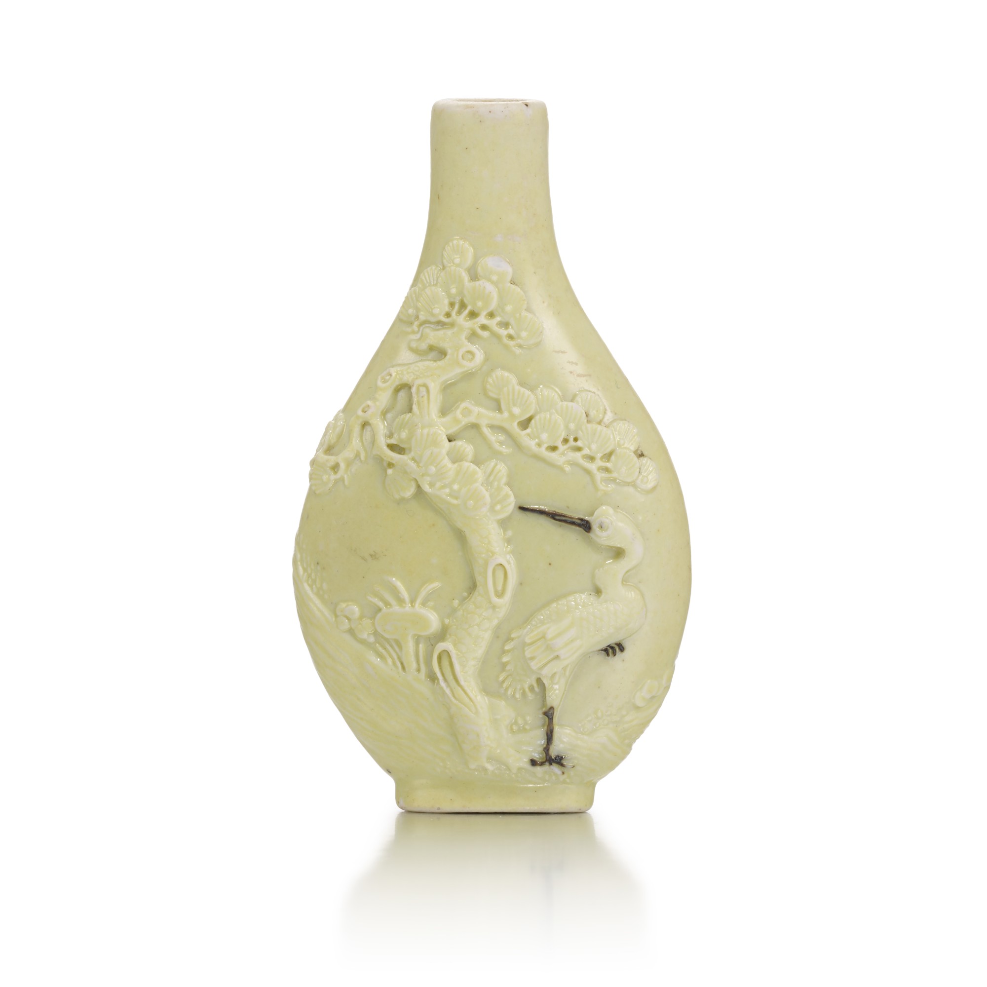 A moulded and yellow-glazed porcelain 'crane' snuff bottle — 二十世紀初 模印黃釉松下仙鶴紋鼻烟壺