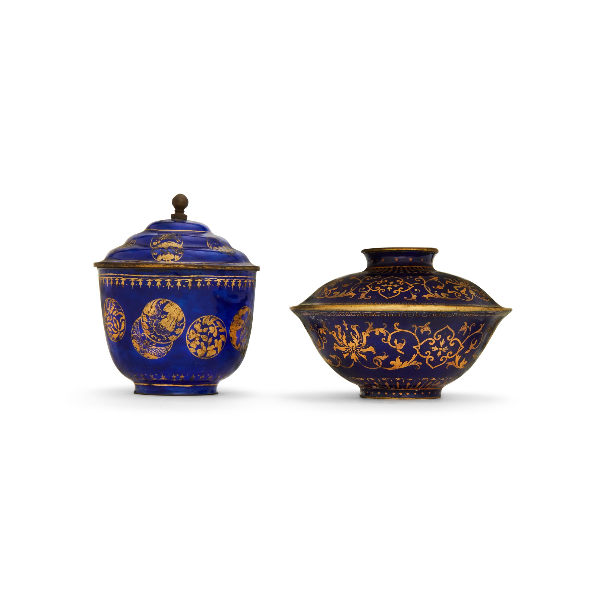 Two blue-ground basse-taille Canton enamel bowls and covers, — 清乾隆 銅胎畫琺瑯藍地描金蓋盌《乾隆年製》款 及 銅胎畫琺瑯藍地描金皮球花紋蓋盃 一組兩件