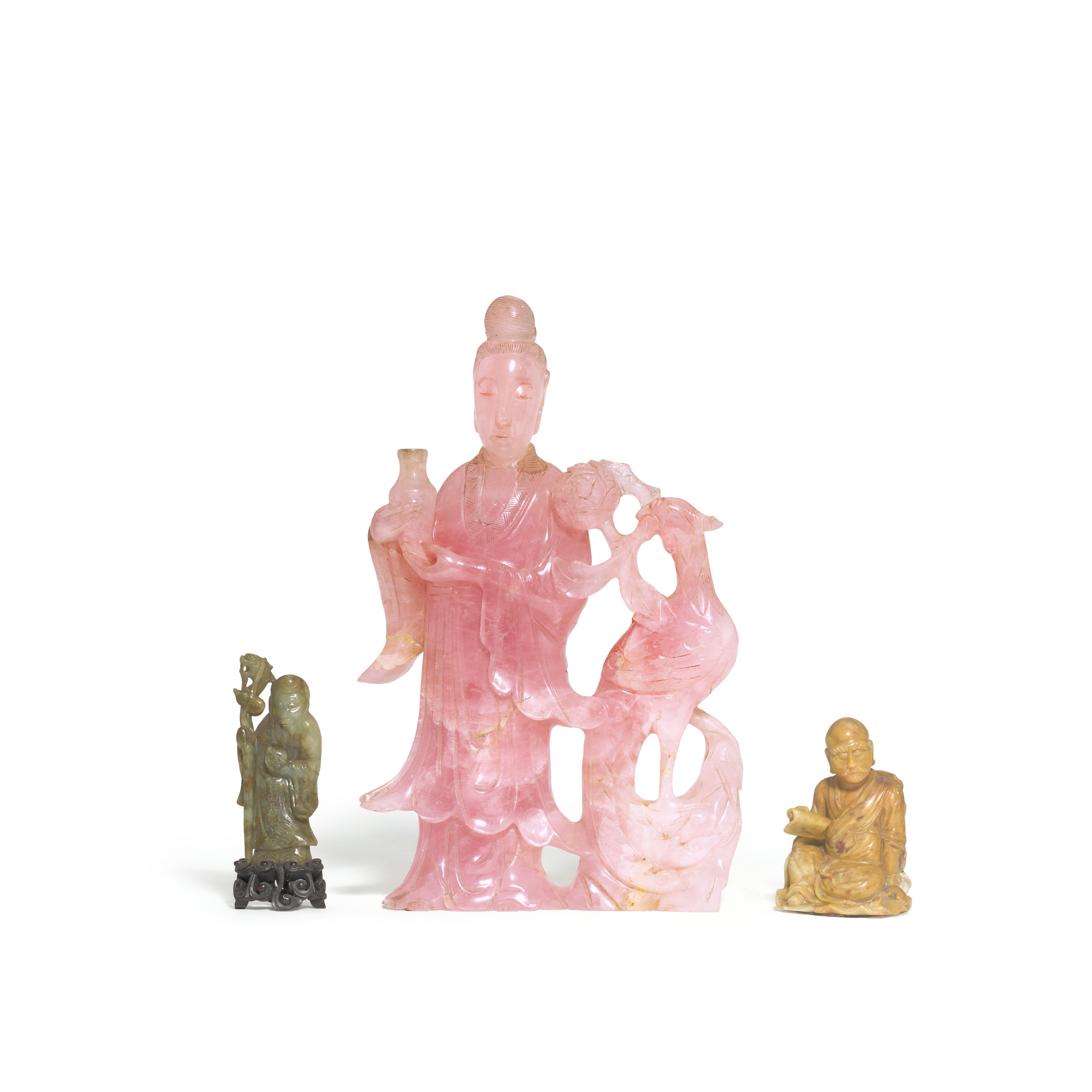A carved soapstone figure of a Luohan, — A carved soapstone figure of a Luohan, Qing dynasty, late 19th century 清十九世紀末 壽山石雕羅漢坐象，青玉壽老立像及 十九 / 二十世紀 粉晶侍女立像 一組三件