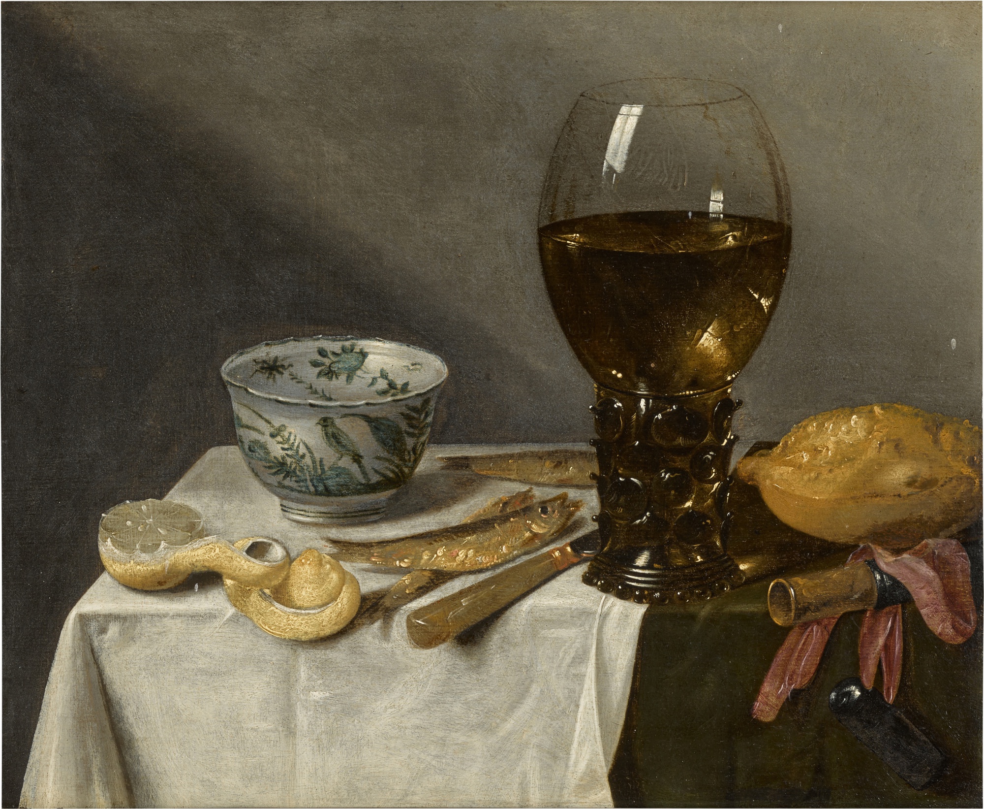 Attributed to Abraham Susenier — Still life with a roemer, porcelain bowl, fish and peeled lemon on a table draped with a white cloth