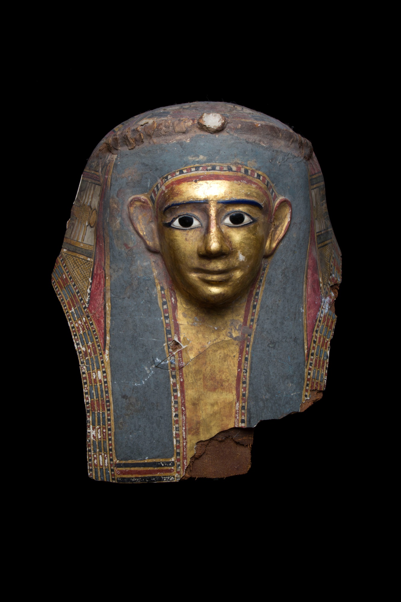 An Egyptian Polychrome and Gilt Cartonnage Mummy Mask — An Egyptian Polychrome and Gilt Cartonnage Mummy Mask, late Ptolemaic/early Roman Period, circa 1st Century B.C./ 1st Century A.D.