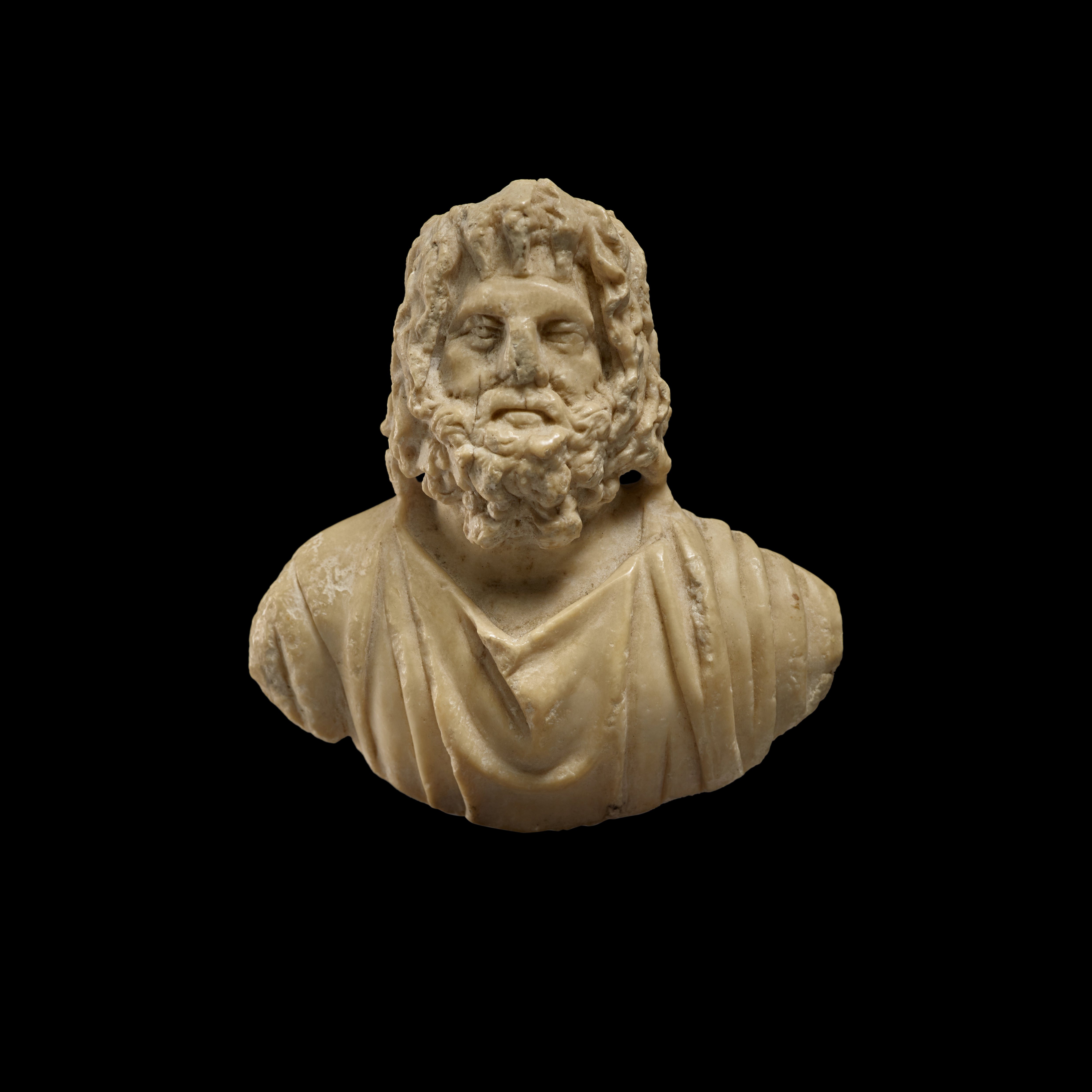 Unknown — A Roman Marble or Indurated Limestone Appliqué Bust of Zeus-Sarapis, circa 2nd Century A.D.