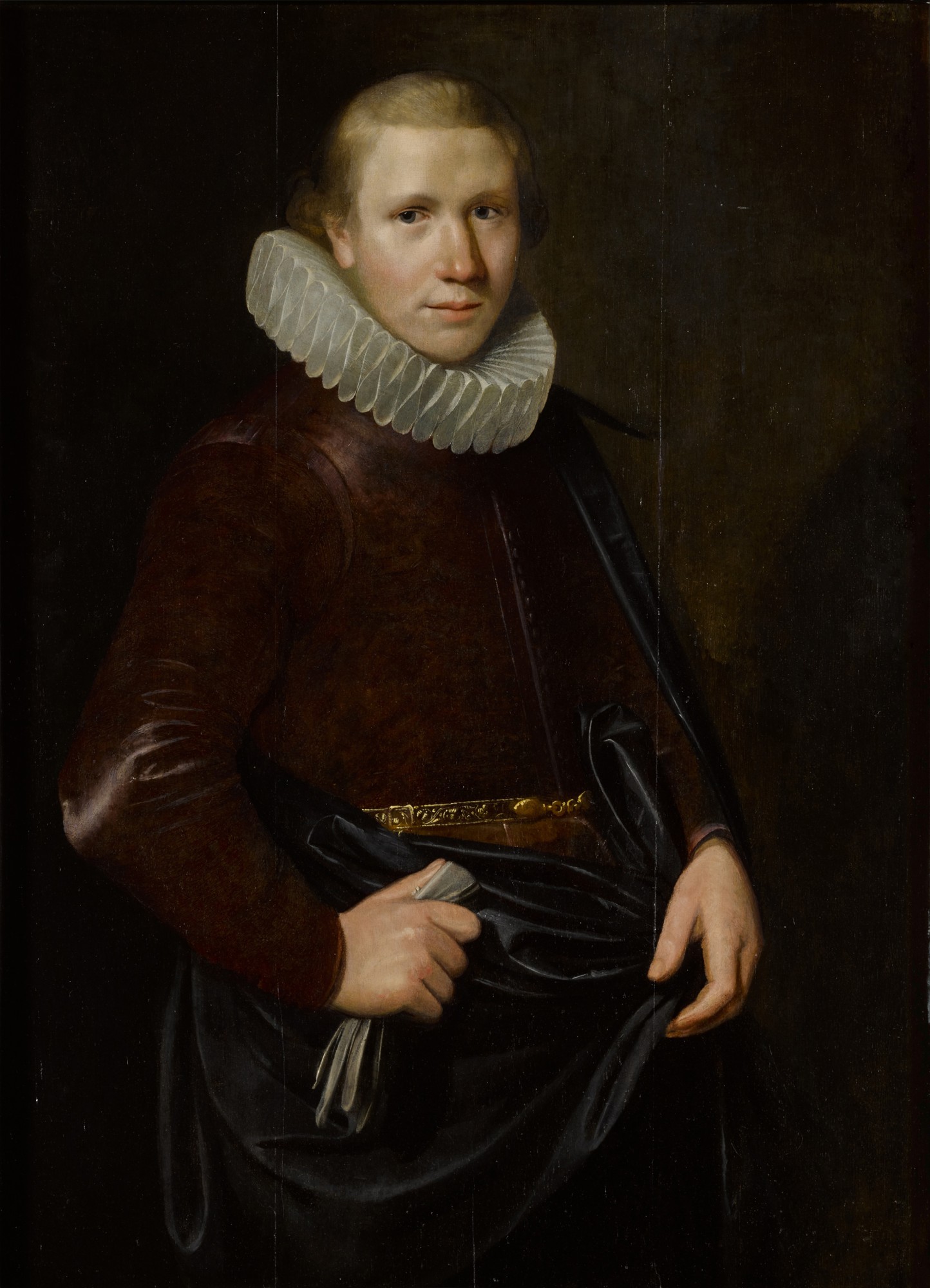 Dutch School, first quarter of the 17th century — Portrait of a young man in a millstone collar, holding gloves, his right arm akimbo, three-quarter length