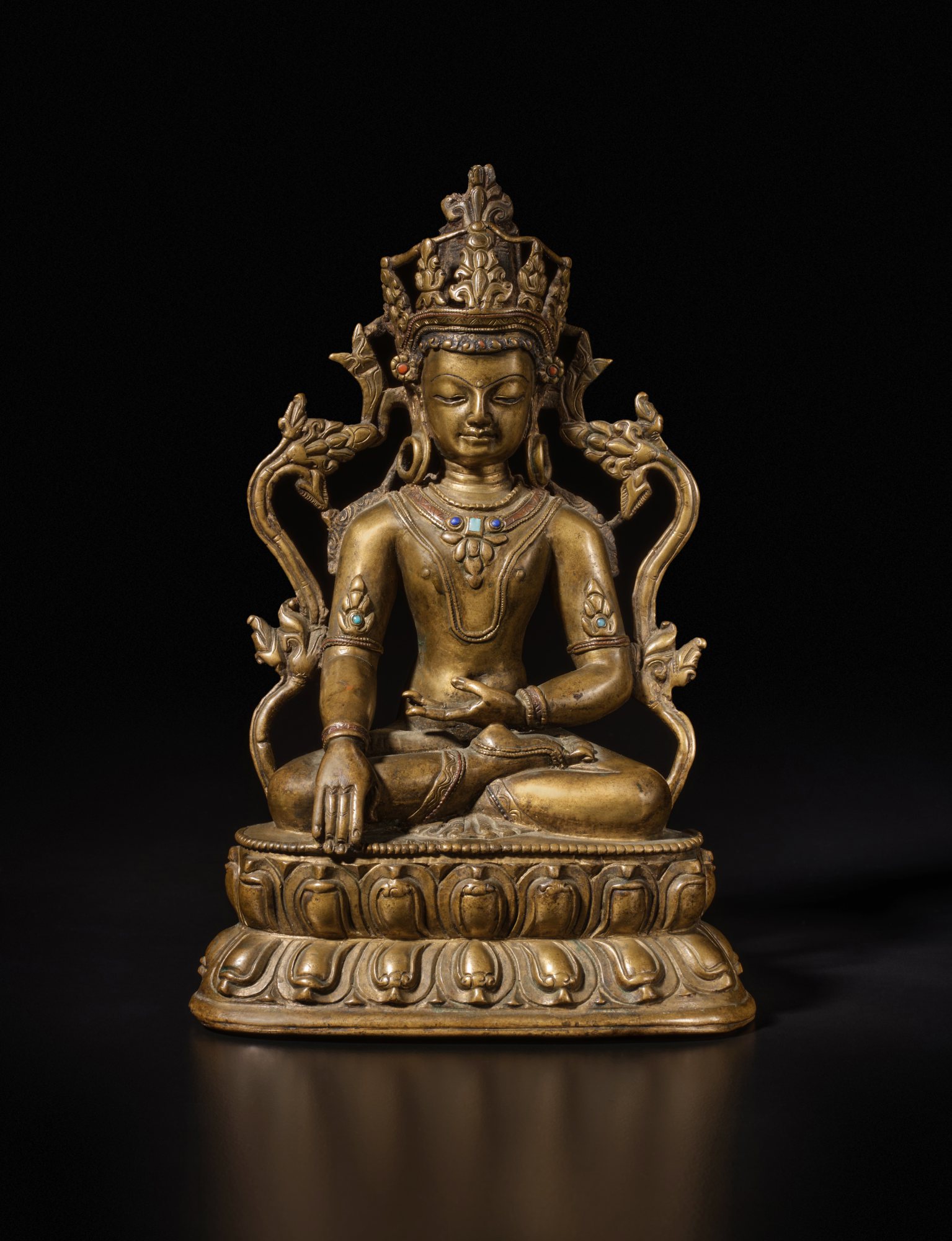 A copper alloy figure of Akshobya Buddha — 西藏 十四世紀 銅合金嵌寶阿閦佛坐像