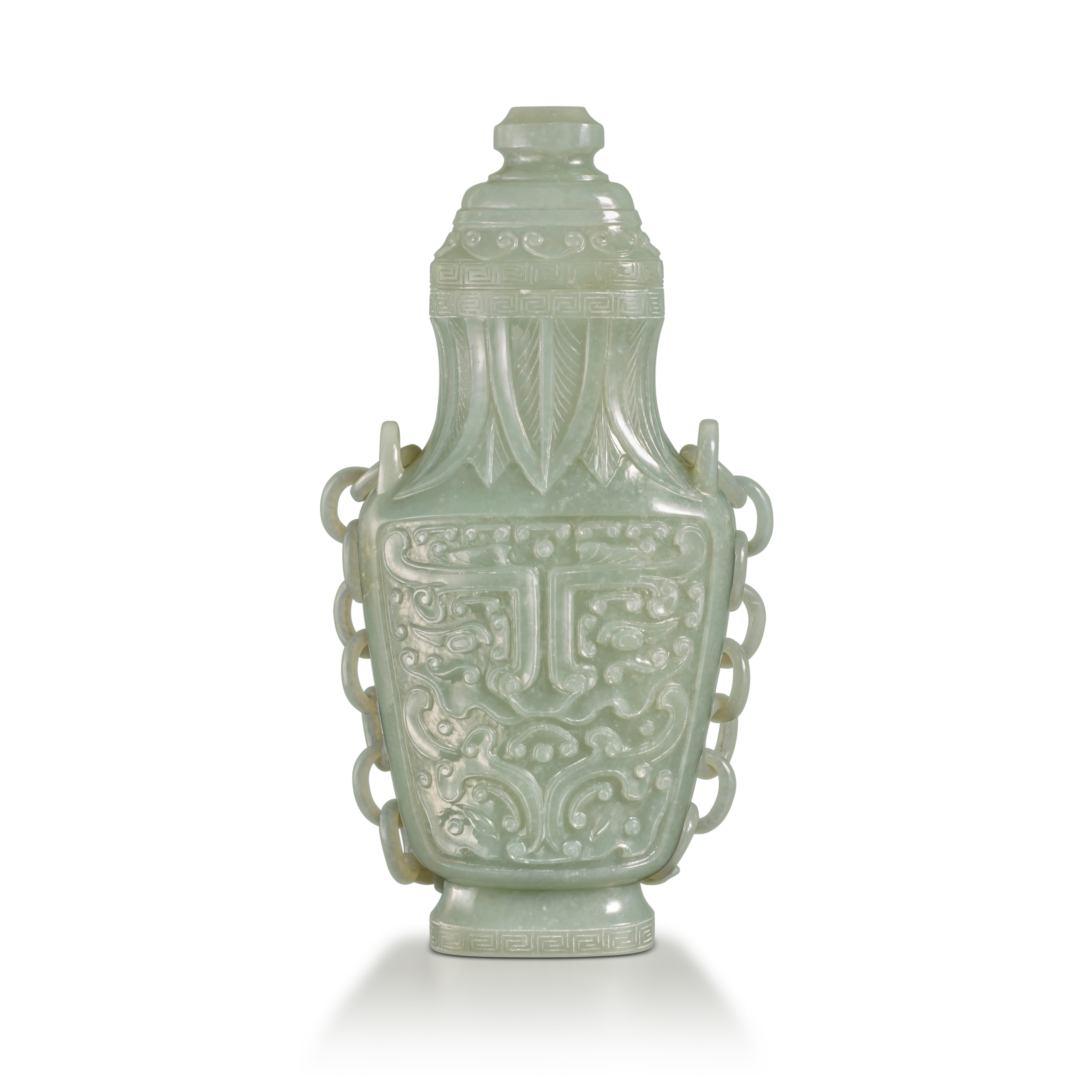 An archaistic celadon jade 'taotie' hanging vase and cover — 清十九世纪 青玉雕仿古饕餮紋提梁蓋瓶