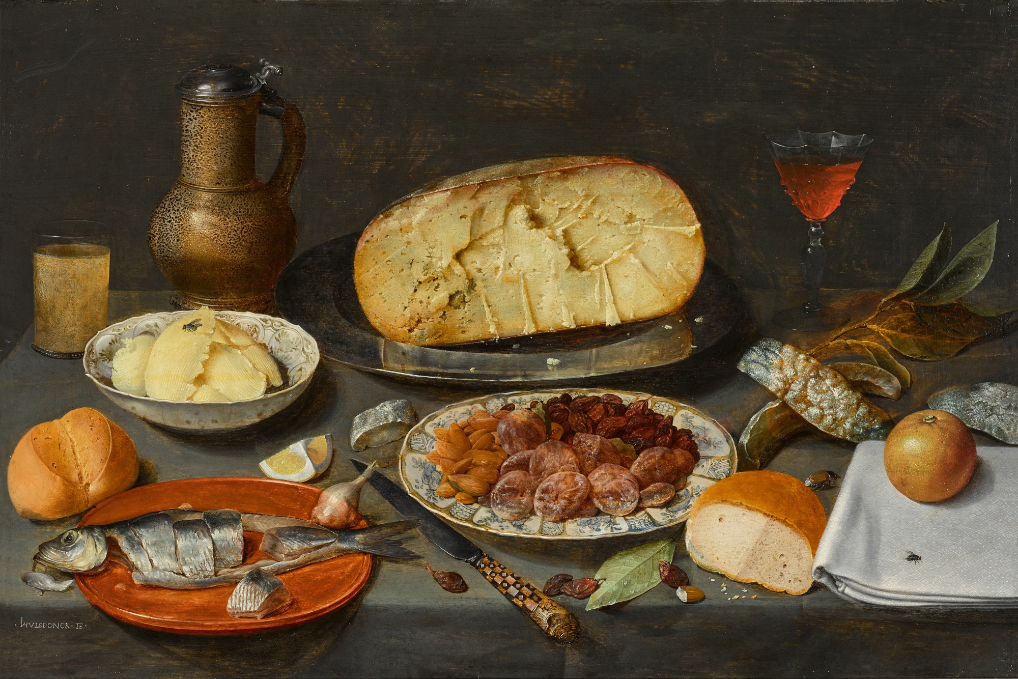 Unknown — Still life with a herring, cheese, preserved fruits and nuts, bread, butter, and a wineglass and jug, all on a draped table