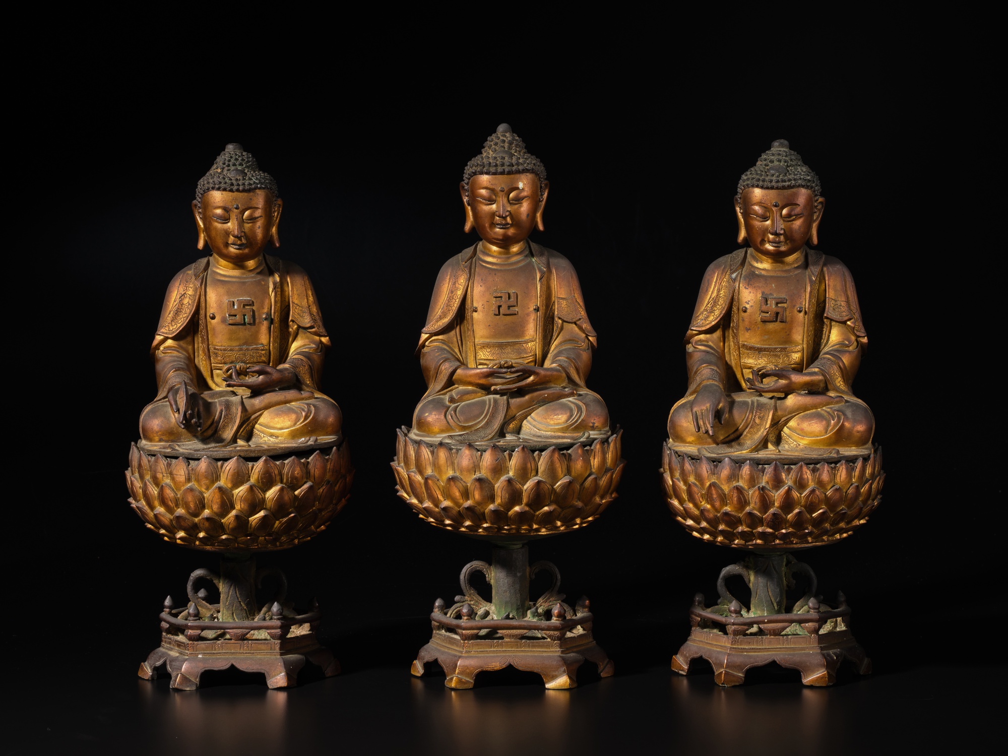 Unknown (Historical) —  A rare set of three gilt-bronze figures of Buddha and stands, Late Ming dynasty