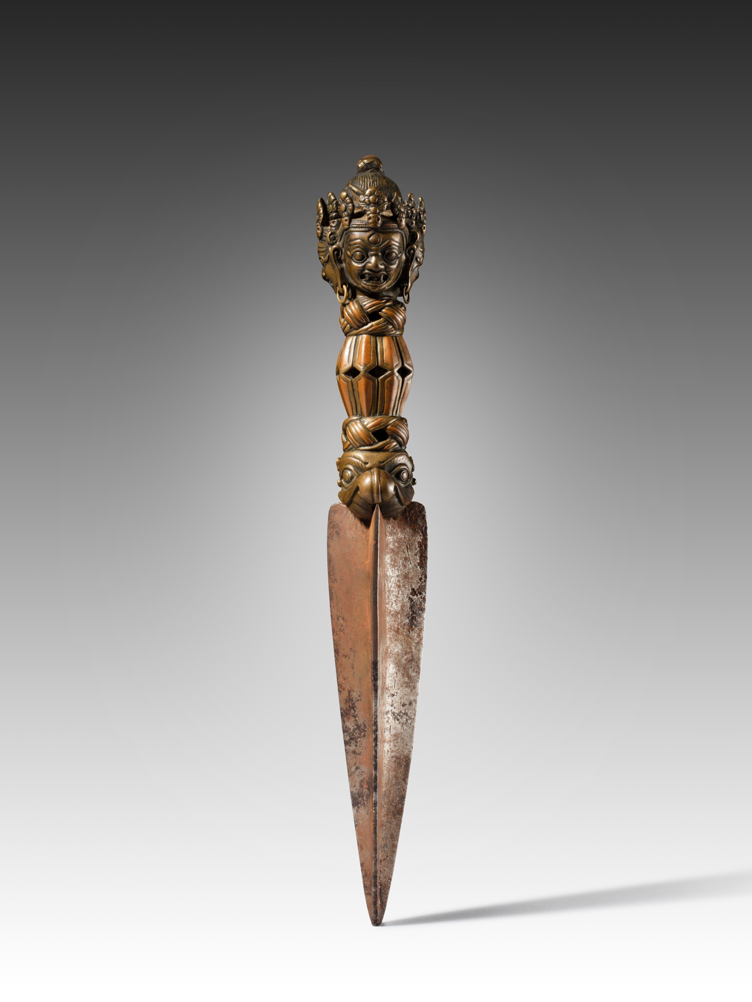 A copper-inlaid copper-alloy and iron dagger (Phurba), — A copper-inlaid copper-alloy and iron ritual dagger, Tibet, 14th century
