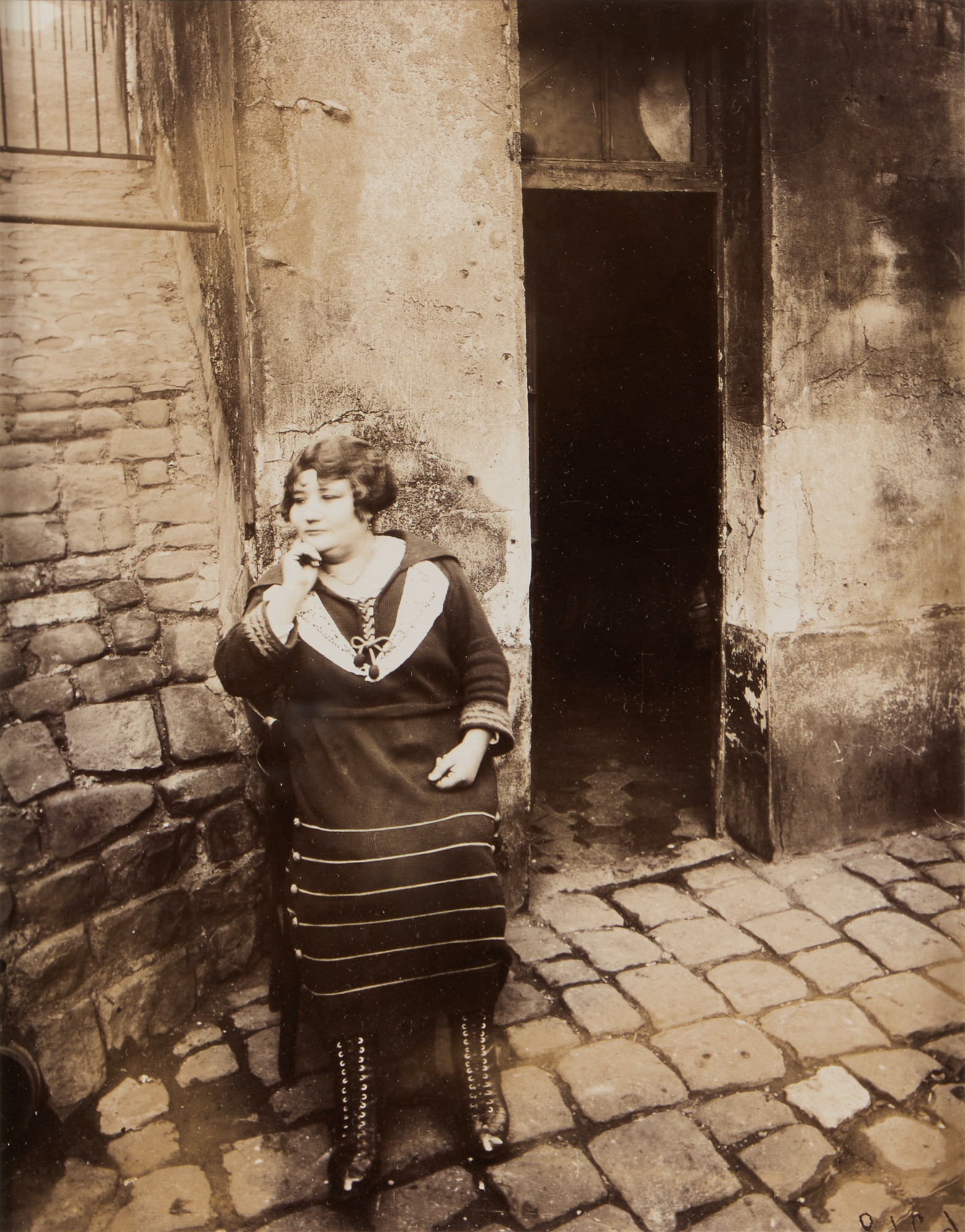 Eugène Atget — 'La Villette, rue Asselin, fille publique faisant le quart devant sa porte, 19e'