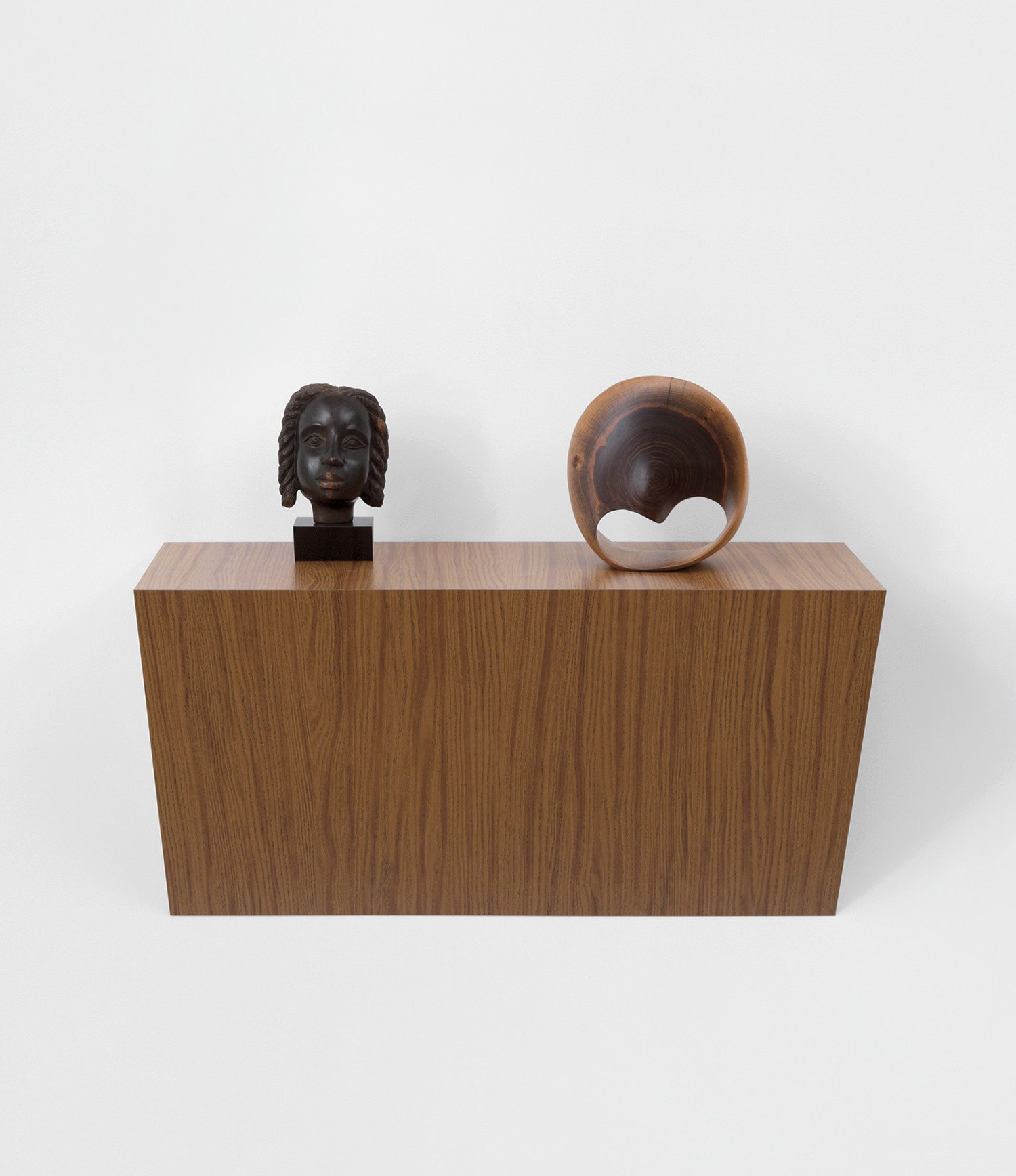 plastic laminated wood shelf, wood Jamaica head sculpture and wood Möbius strip sculpture
