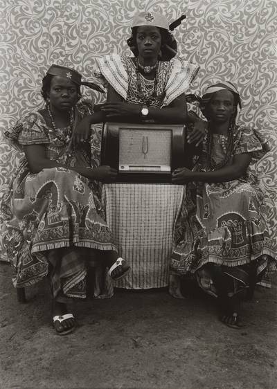 Three women wearing 'Grand dakar' dresses and 'a la de gaulle' headscarves