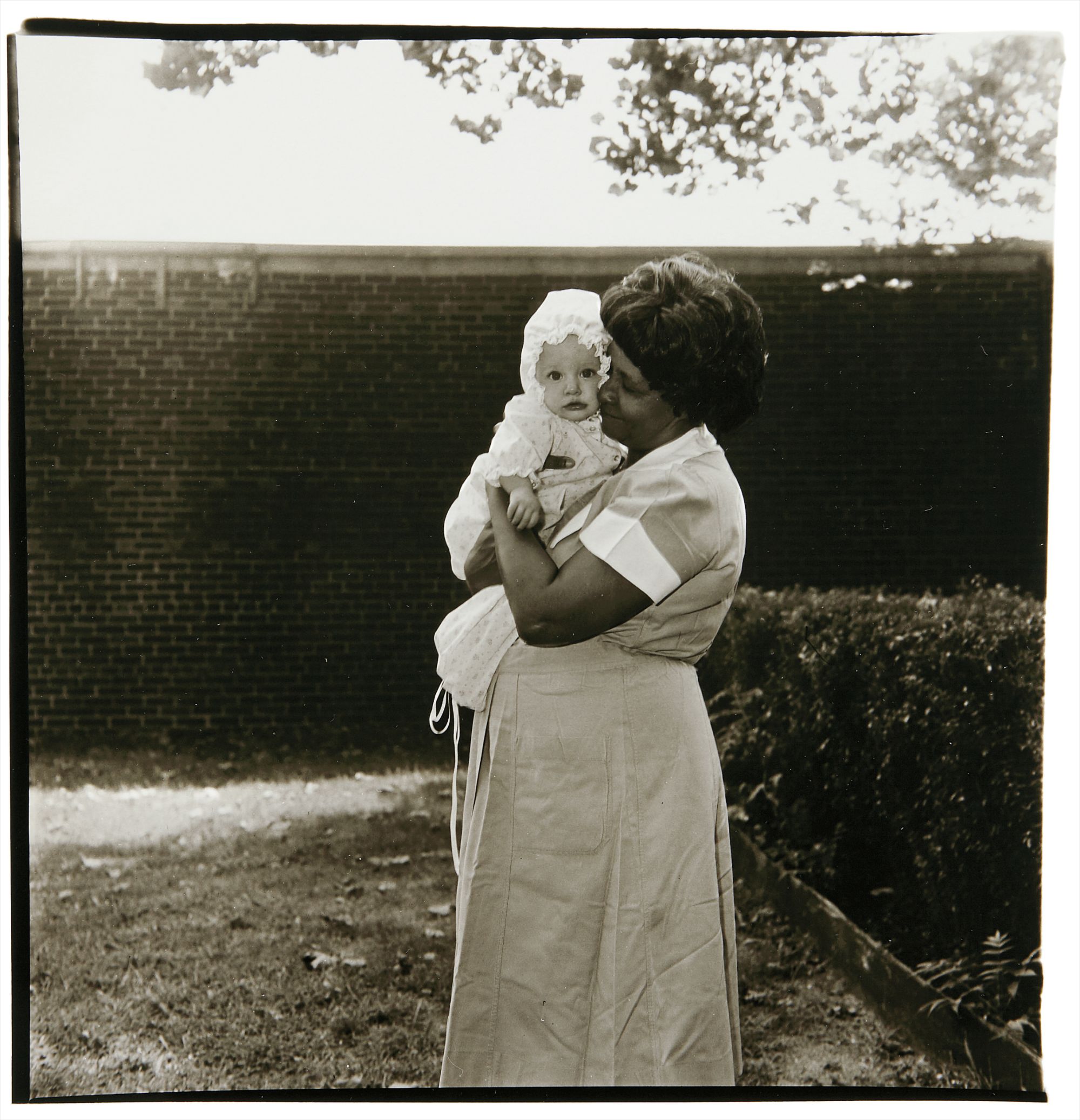 Diane Arbus — Toddler being held in garden, N.J.