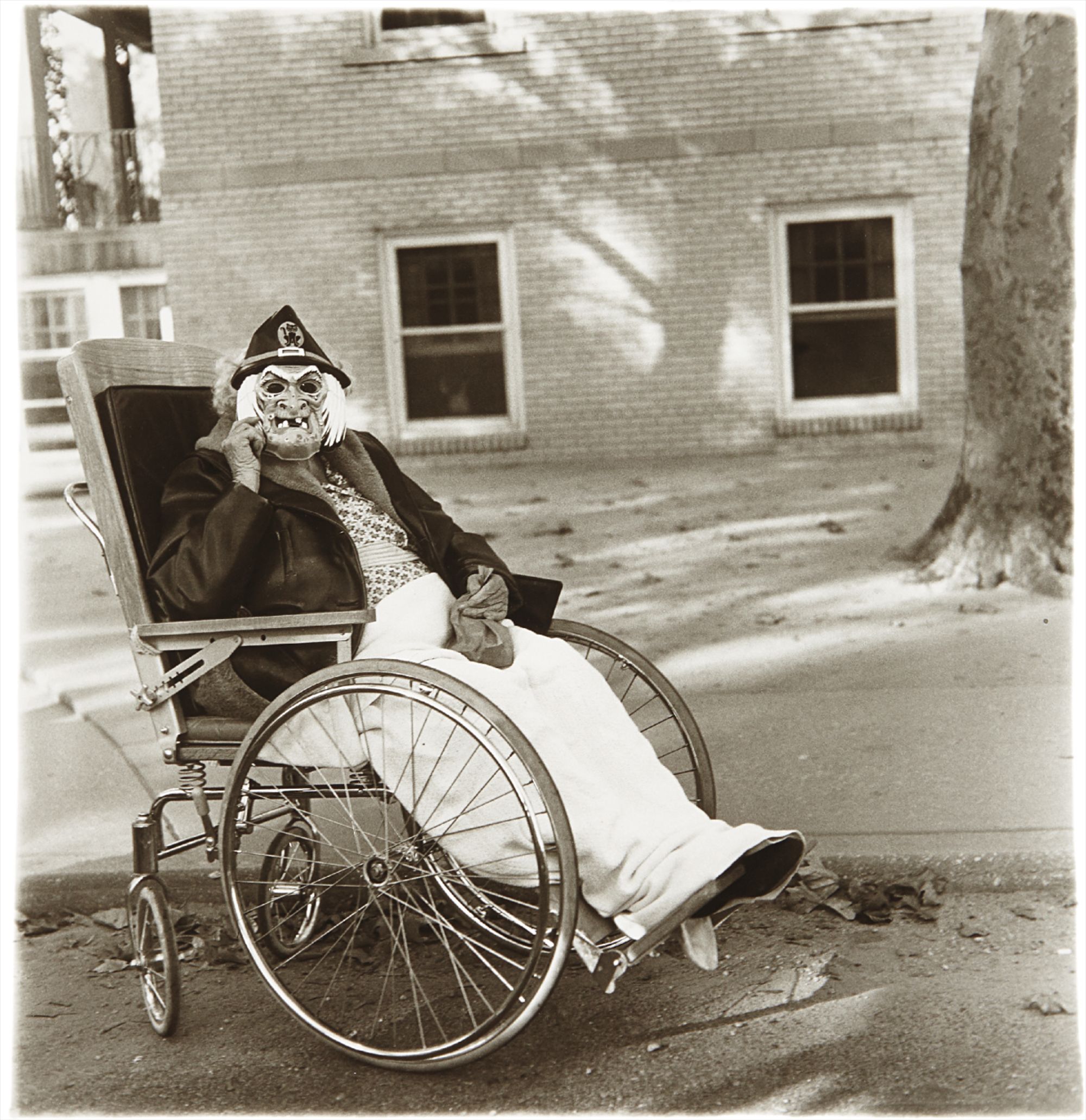 Diane Arbus — Masked woman in wheelchair, P.A.