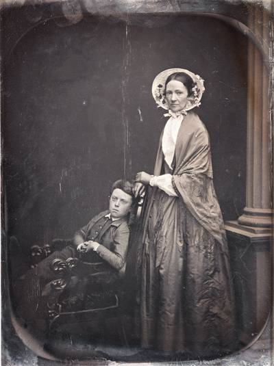 A Woman in Bonnet & Shawl, with Her Seated Son