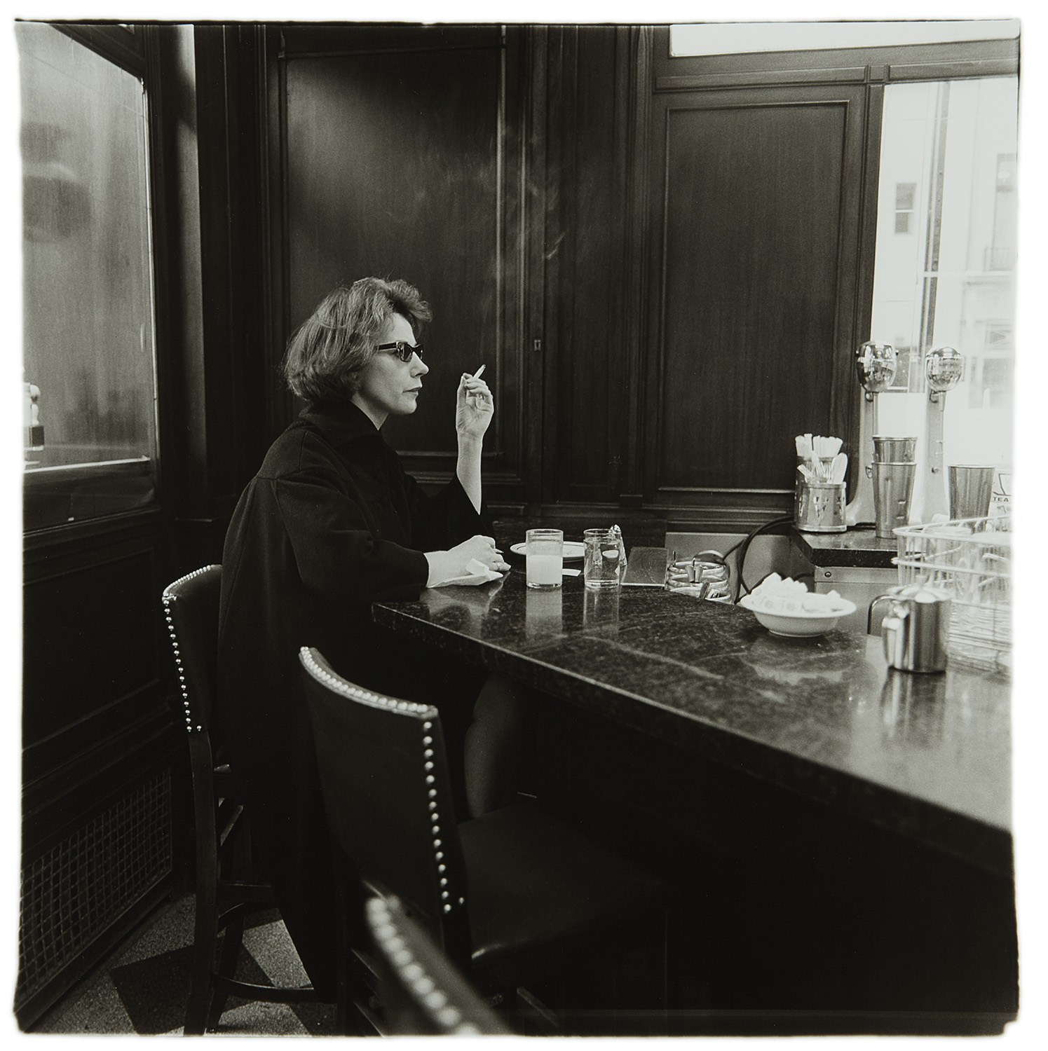 Diane Arbus — Woman at a counter smoking, N.Y.C.