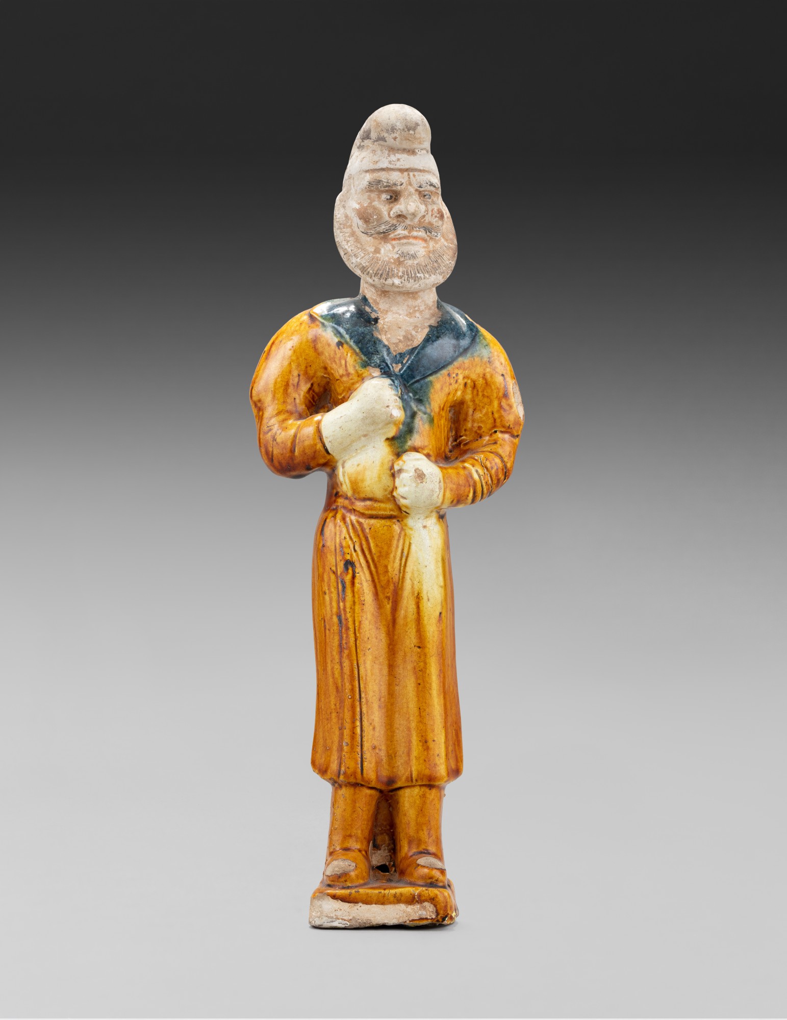 A sancai-glazed pottery figure of a standing camel groom — 唐 三彩胡人立像