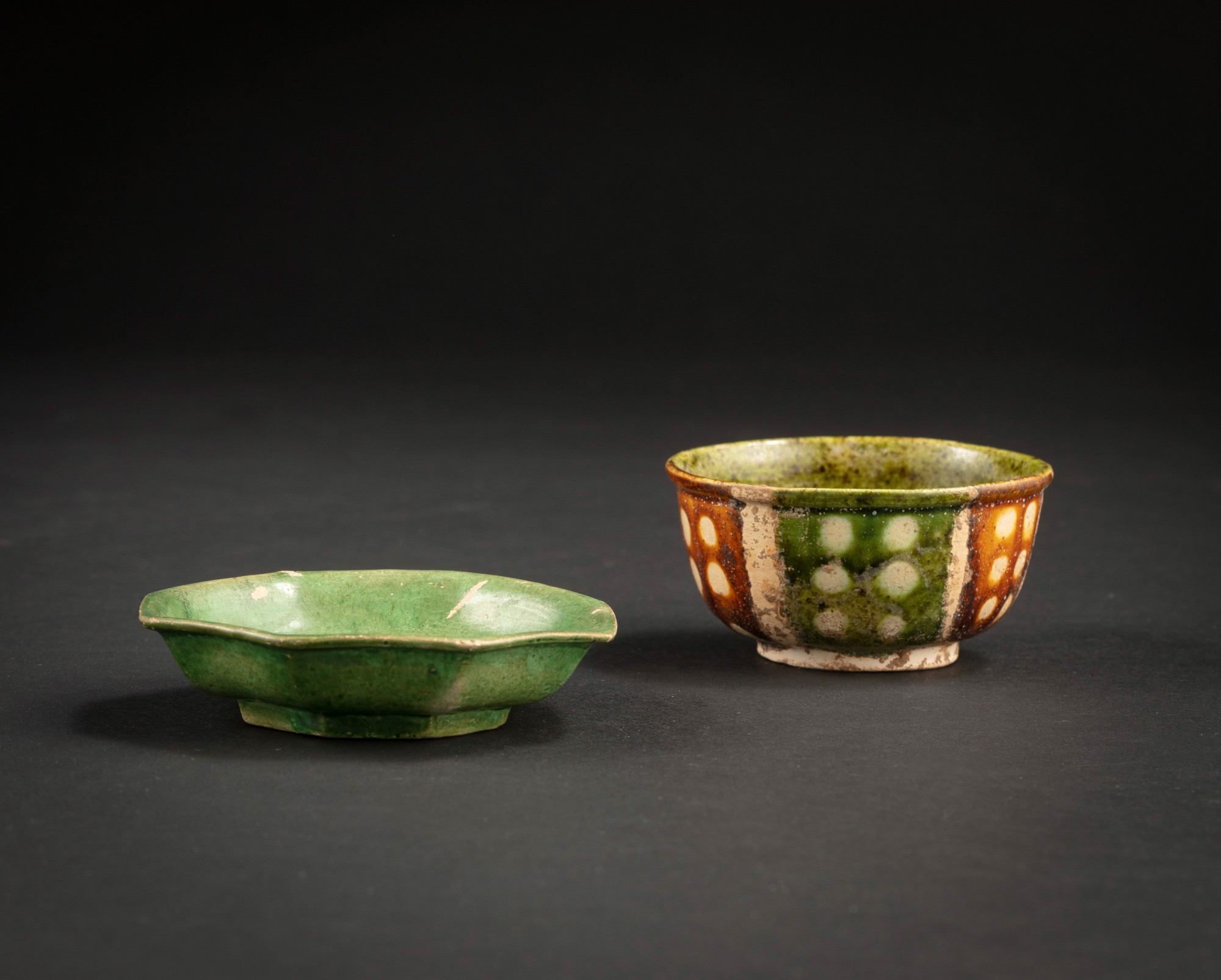 A sancai-glazed cup and a green-glazed octogonal saucer — 唐及遼 三彩盃及青釉八方小盤一組兩件