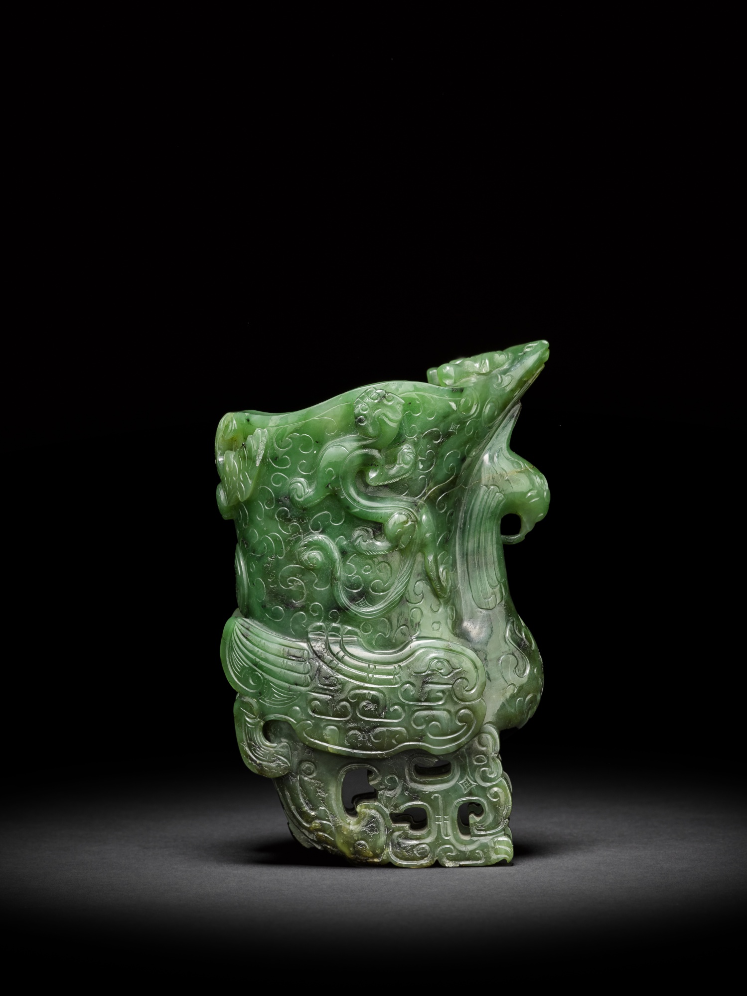 A spinach-green jade archaistic 'phoenix' rhyton — 清十八世紀 碧玉雕仿古祥鳳螭龍觥