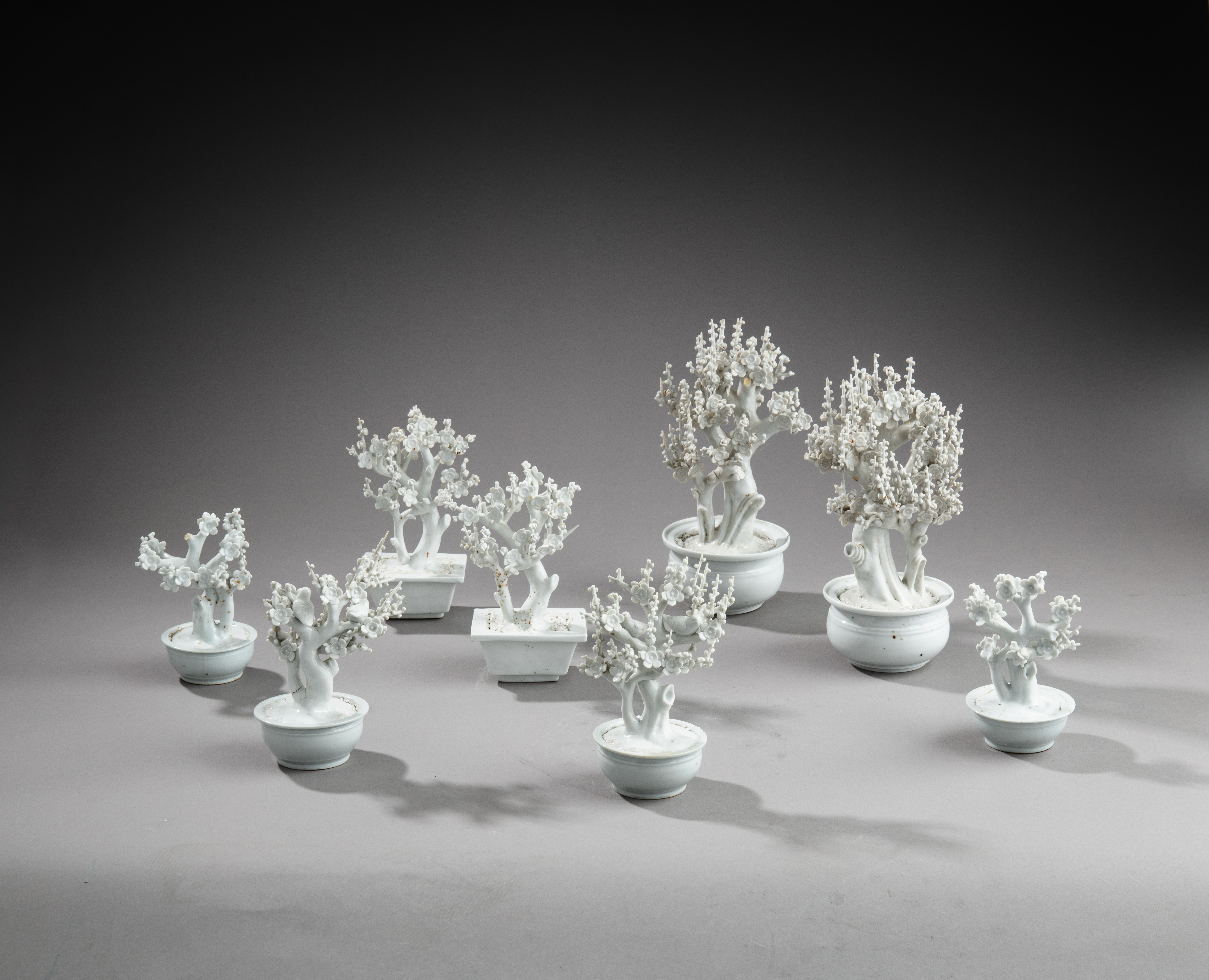 A group of eight 'Dehua' miniature prune trees — 十七至十八世紀 德化梅樹擺件一組八件