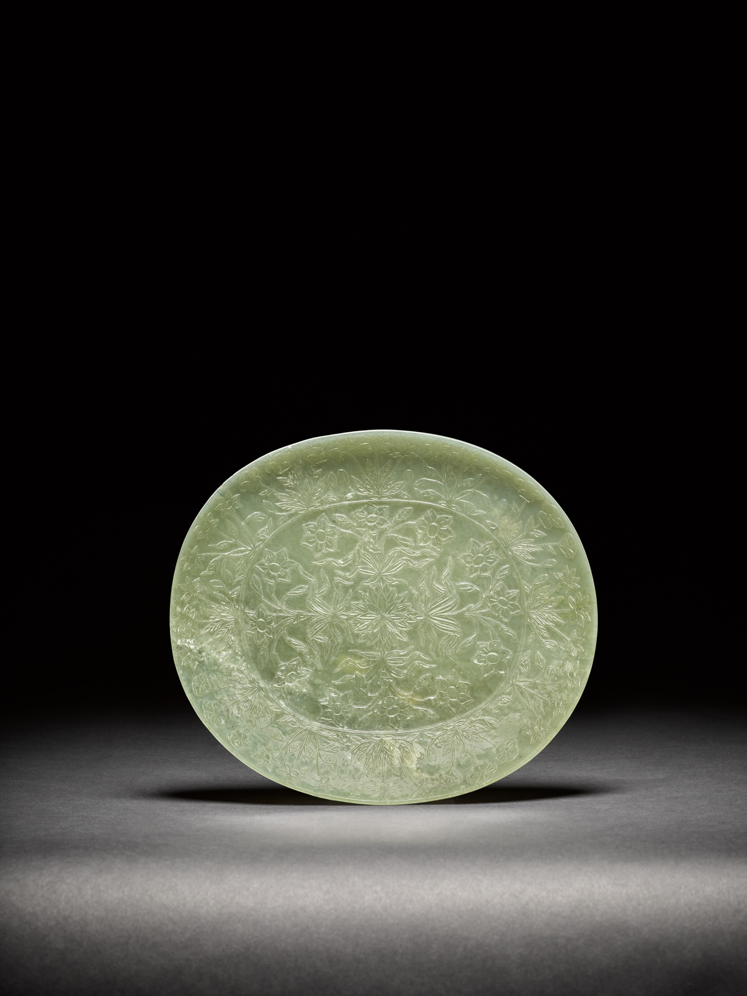 A celadon jade Mughal-style oval dish — 清十八至十九世紀 青玉雕痕都斯坦式花卉紋盤