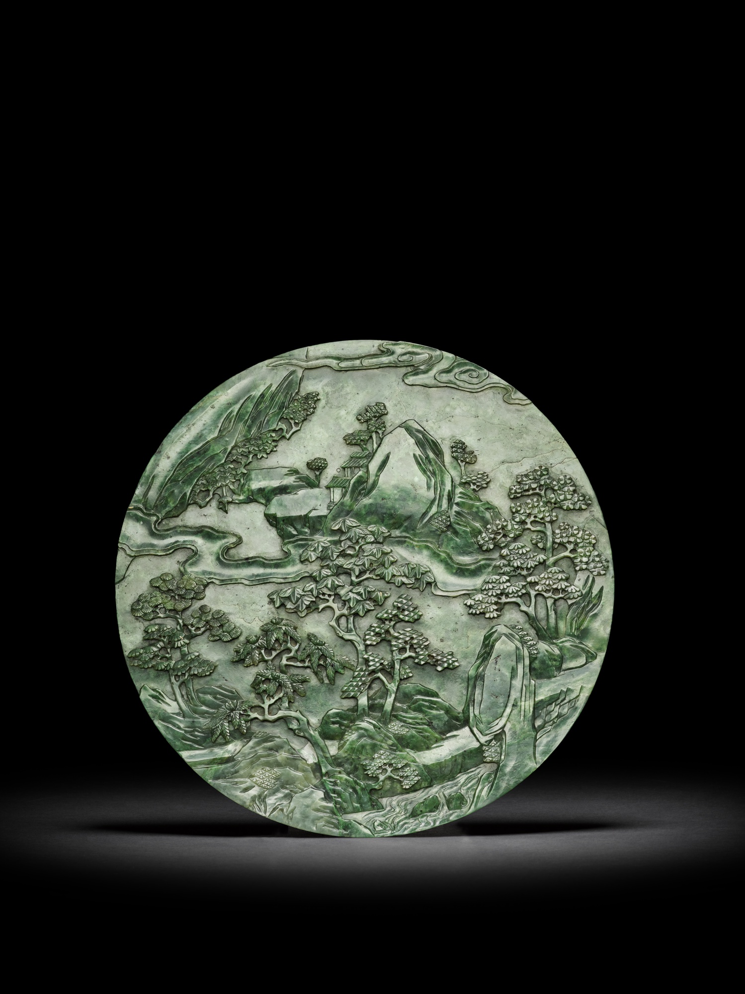 A spinach-green jade 'landscape' circular table screen — 清乾隆 碧玉山水紋圓插屏