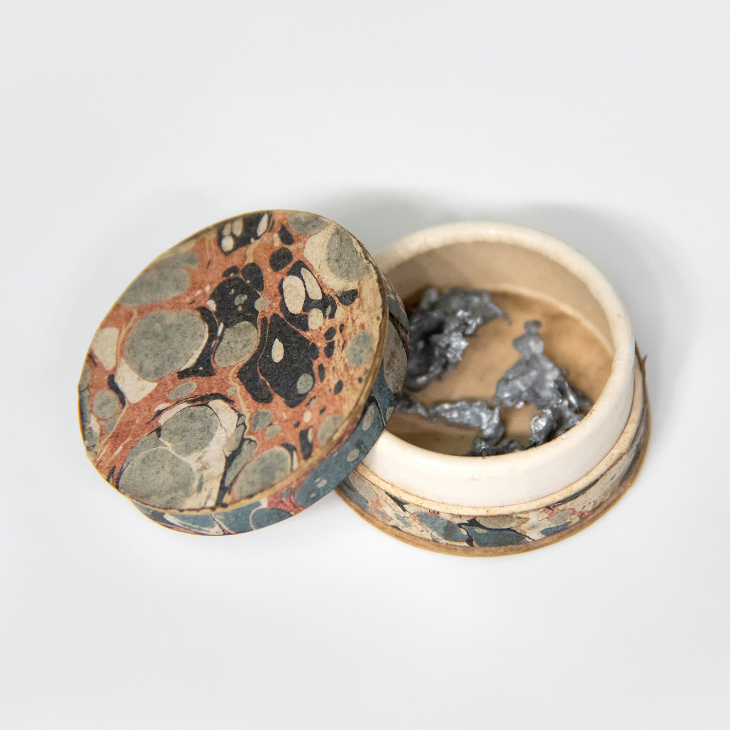 printed paper on cardboard box and metal fragments