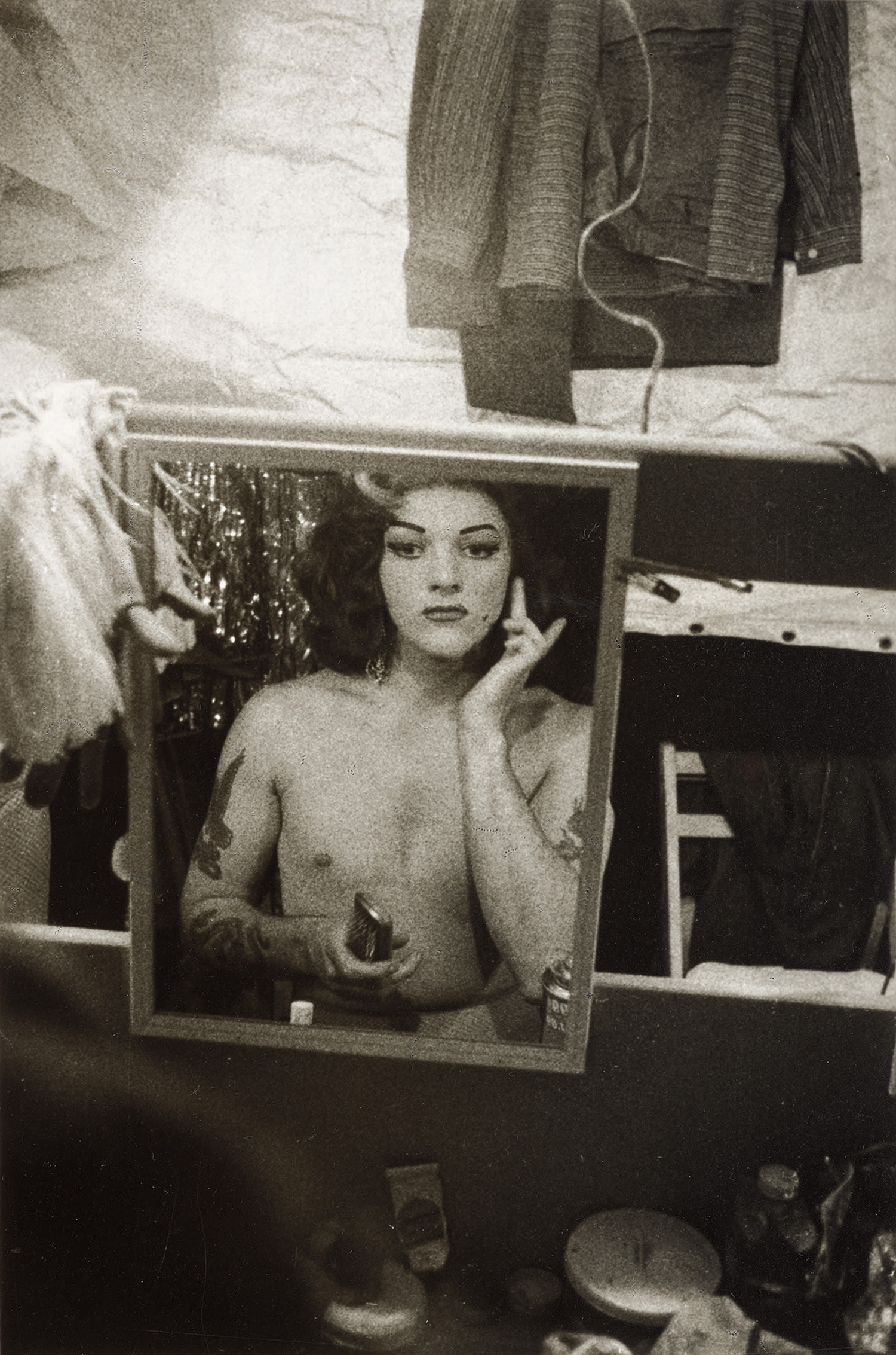 Diane Arbus — Tattooed female impersonator applying make-up in a mirror, N.Y.C.