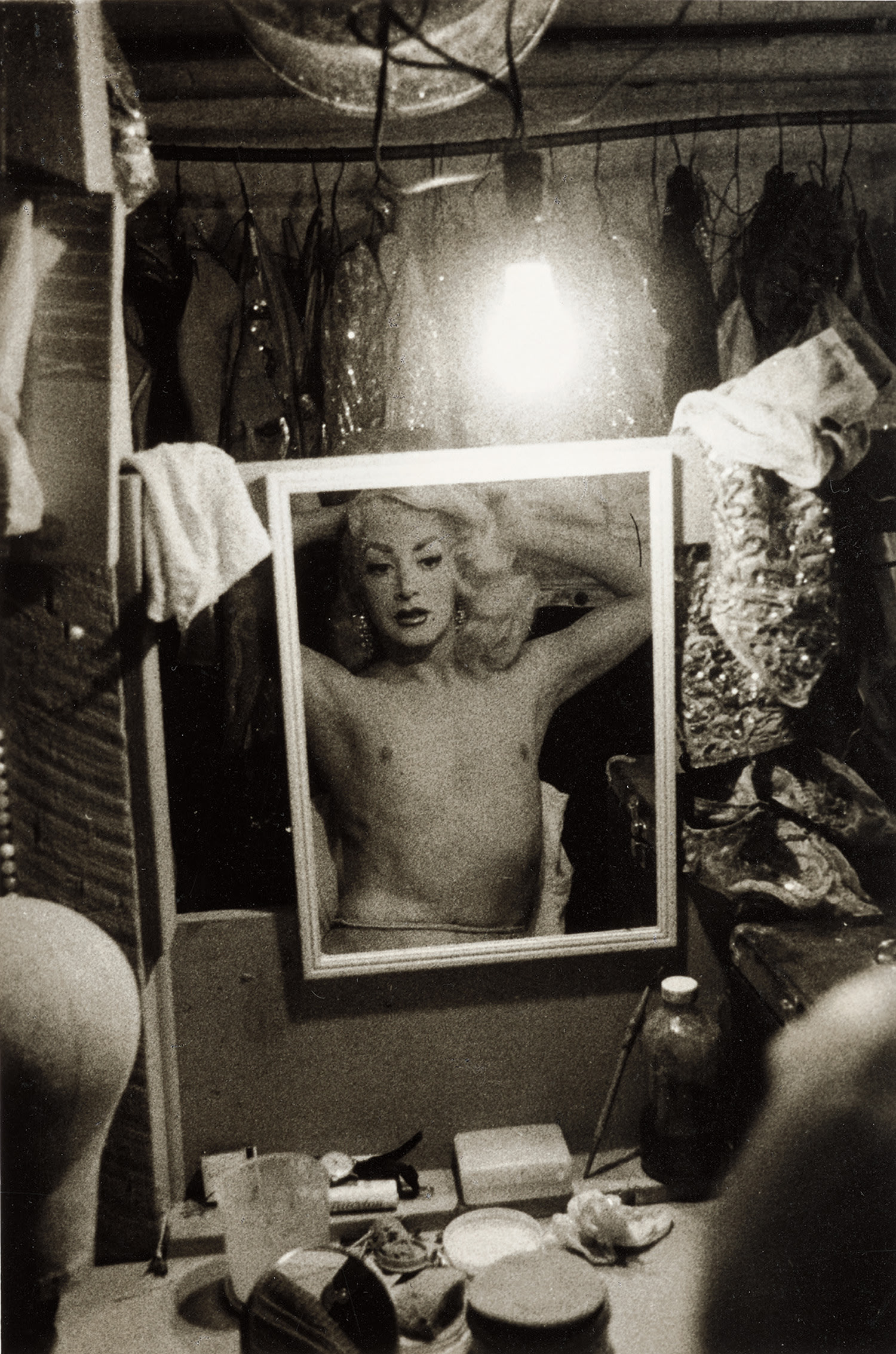 Diane Arbus — Blonde female impersonator framed in a mirror beneath a light bulb, N.Y.C.